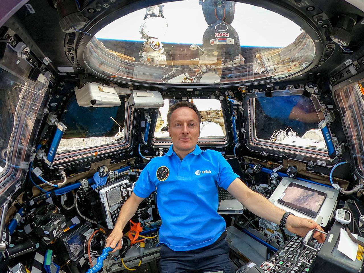 iss066e085145 (Nov. 30, 2021) --- ESA (European Space Agency) astronaut and Expedition 66 Flight Engineer Matthias Maurer is pictured inside the seven-windowed cupola, the International Space Station's "window to the world." Just outside the cupola and behind Maurer is a portion of the Soyuz MS-19 crew ship docked to the Rassvet module and the Prichal docking module attached to the Nauka multipurpose laboratory service module.