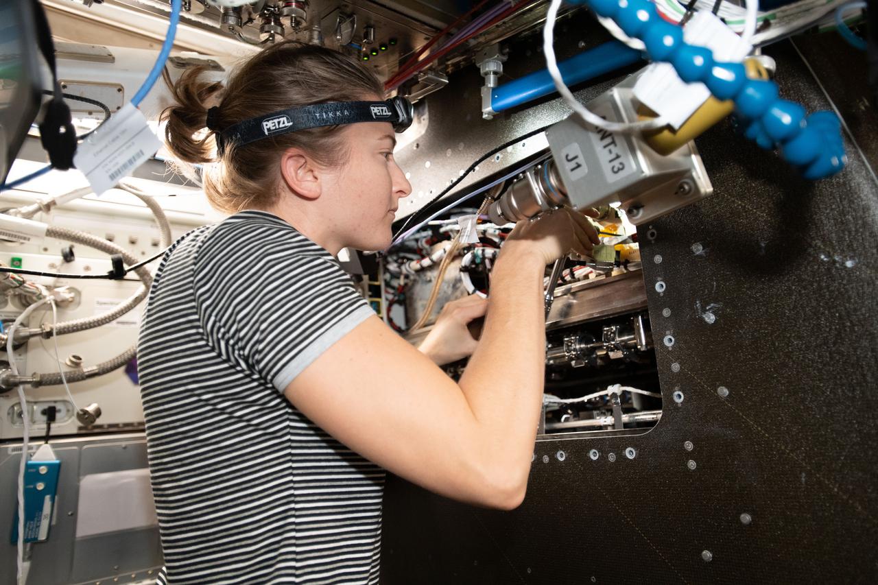 iss066e086417 (Dec. 4, 2021) --- NASA astronaut and Expedition 66 Flight Engineer Kayla Barron inspects cables inside the Materials Science Research Rack. The space physics research device enables the observation of many material types, such as metals, alloys, polymers, semiconductors, ceramics, crystals, and glasses, to study and discover new applications for existing materials and new or improved materials.