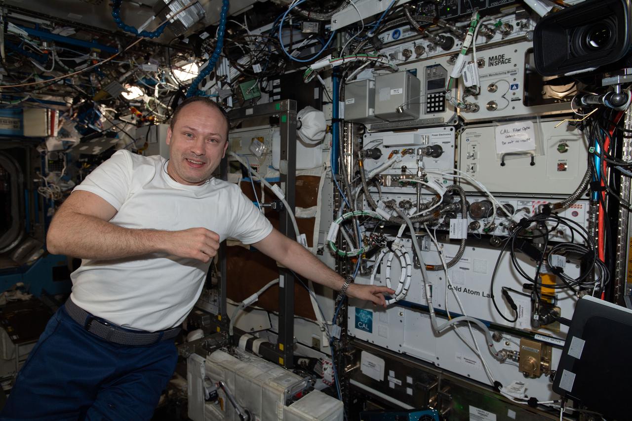 iss066e088442 (Dec. 11, 2021) --- Roscosmos cosmonaut and Soyuz MS-20 Commander Alexander Misurkin is pictured next to the Cold Atom Lab inside the International Space Station's U.S. Destiny module. The space physics research device enables observations of atoms chilled to temperatures near absolute zero allowing scientists to study fundamental behaviors and quantum characteristics not possible on Earth.