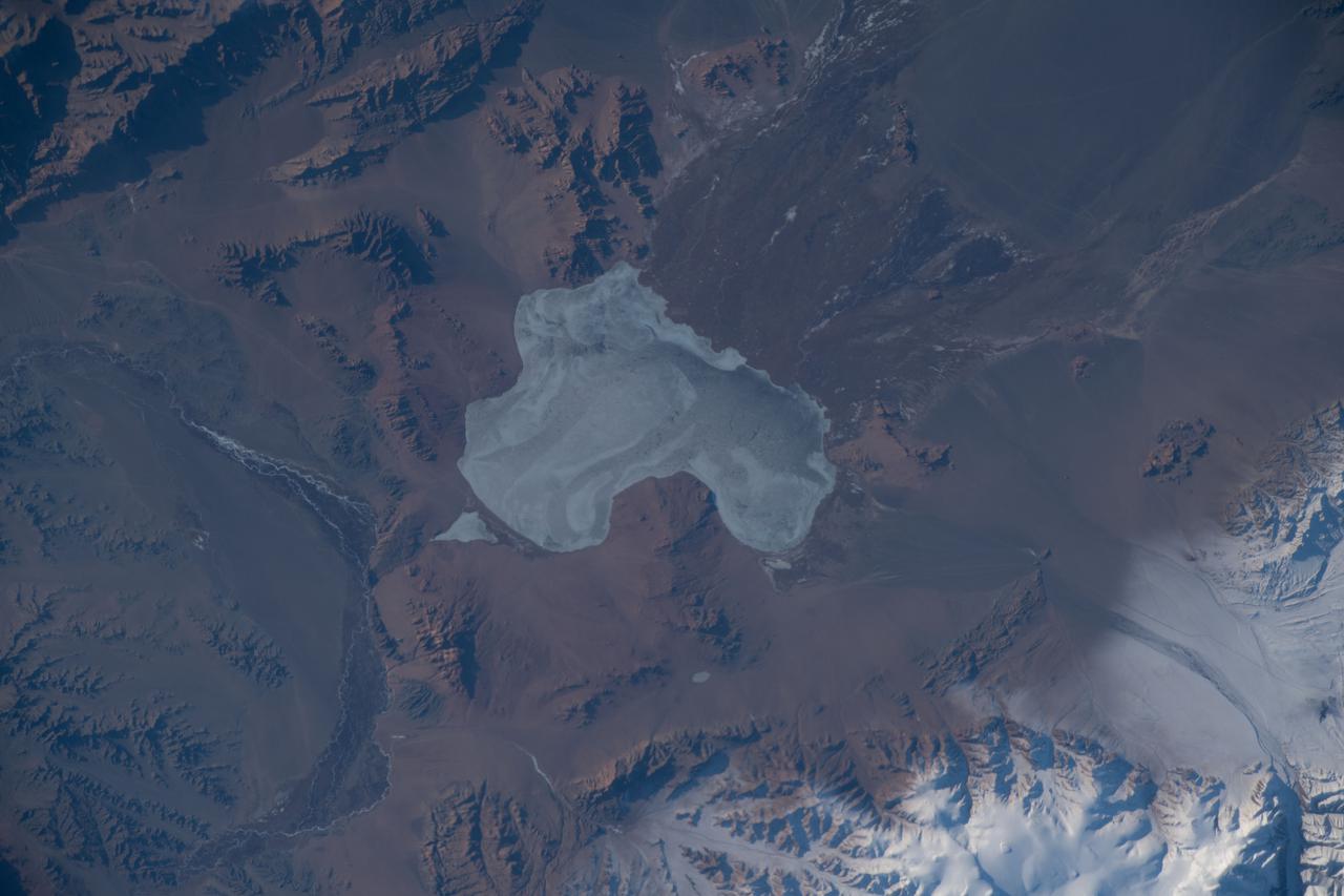 iss066e090079 (Dec. 11, 2021) --- The frozen Achit Lake, in the Altay Mountain range of the Central Asian nation of Mongolia, is pictured from the International Space Station as it orbited 266 miles above. Just west of Achit Lake is the Harhiraa Uul mountain (at bottom right) with an elevation of 13,255 feet, or 4040 meters.