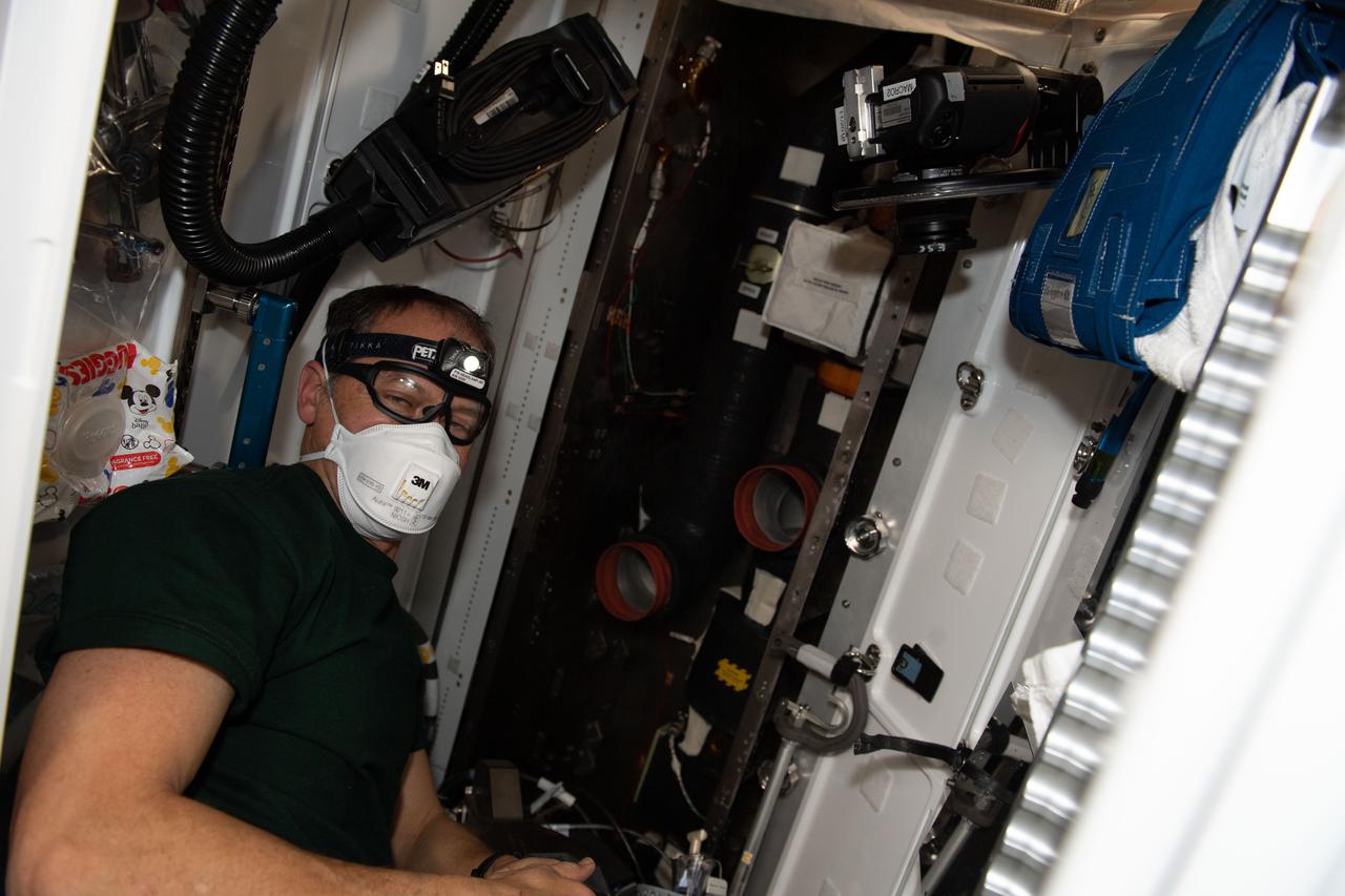 iss066e101967 (Jan. 3, 2022) --- NASA astronaut and Expedition 66 Flight Engineer Thomas Marshburn is pictured cleaning the ventilation system inside the International Space Station's Tranquility module.