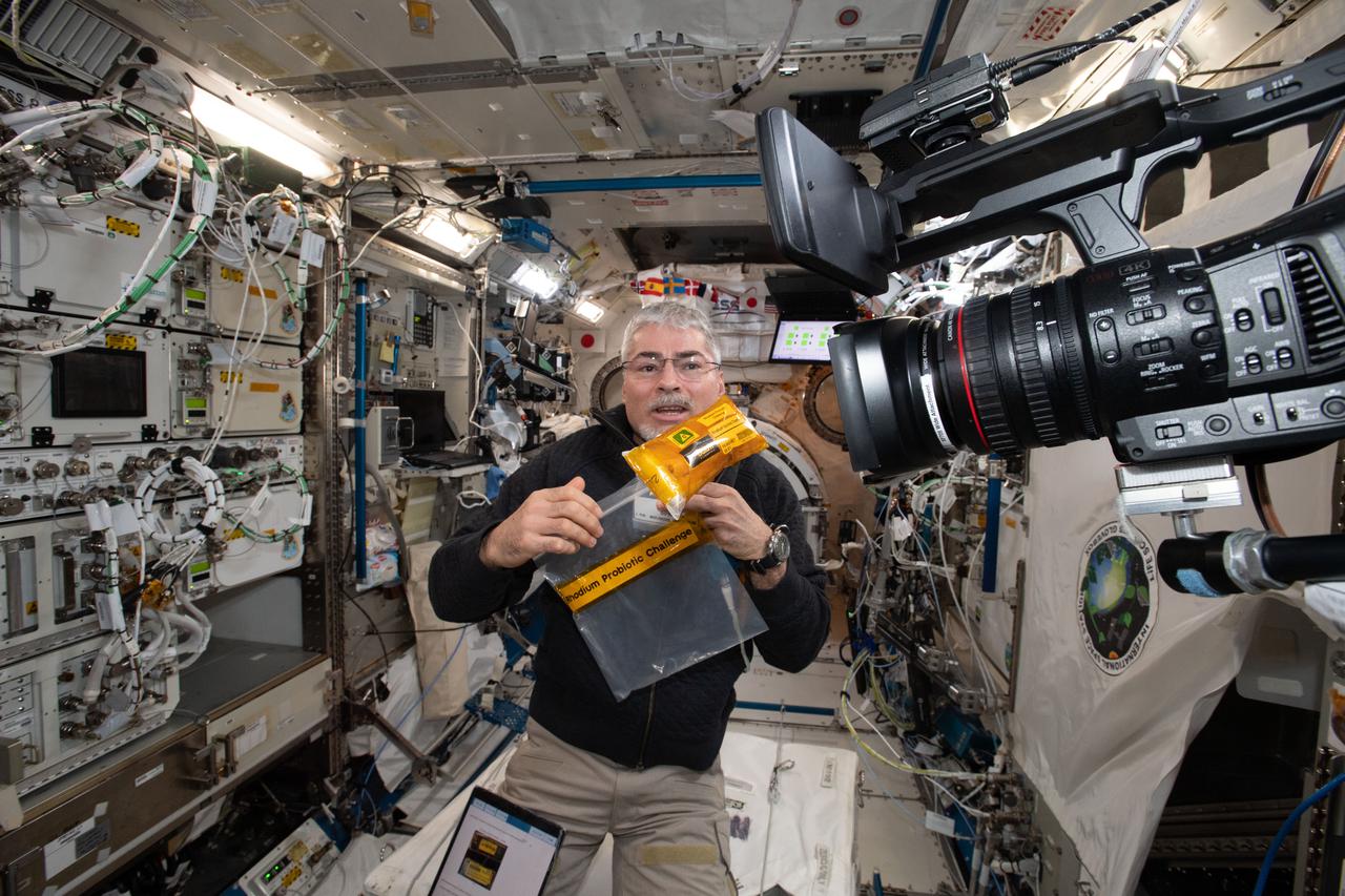 iss066e114368 (1/15/2022) --- NASA astronaut Mark Vande Hei is picured with the Rhodium Probiotic Challenge samples aboard the International Space Station. The Swinburne Youth Space Innovation Challenge 2021: Microgravity Production of a Probiotic Yoghurt Using Active Bacterial Cultures (Rhodium Probiotic Challenge) investigation tests methods for producing yoghurt in space.