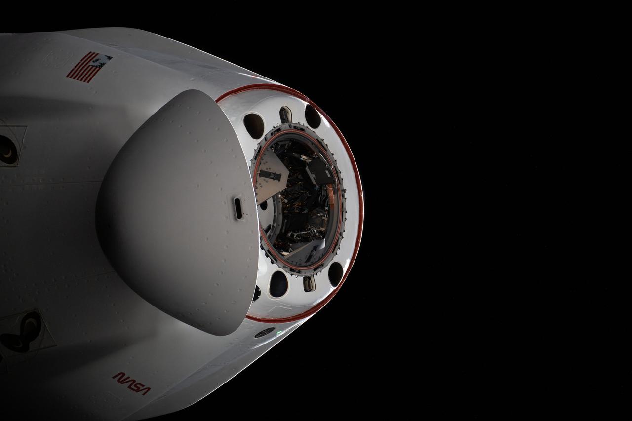 iss066e125308 (Jan. 23, 2022) --- The pressurized capsule of the SpaceX Cargo Dragon resupply ship with its nose cone open is pictured as the vehicle departs the International Space Station.