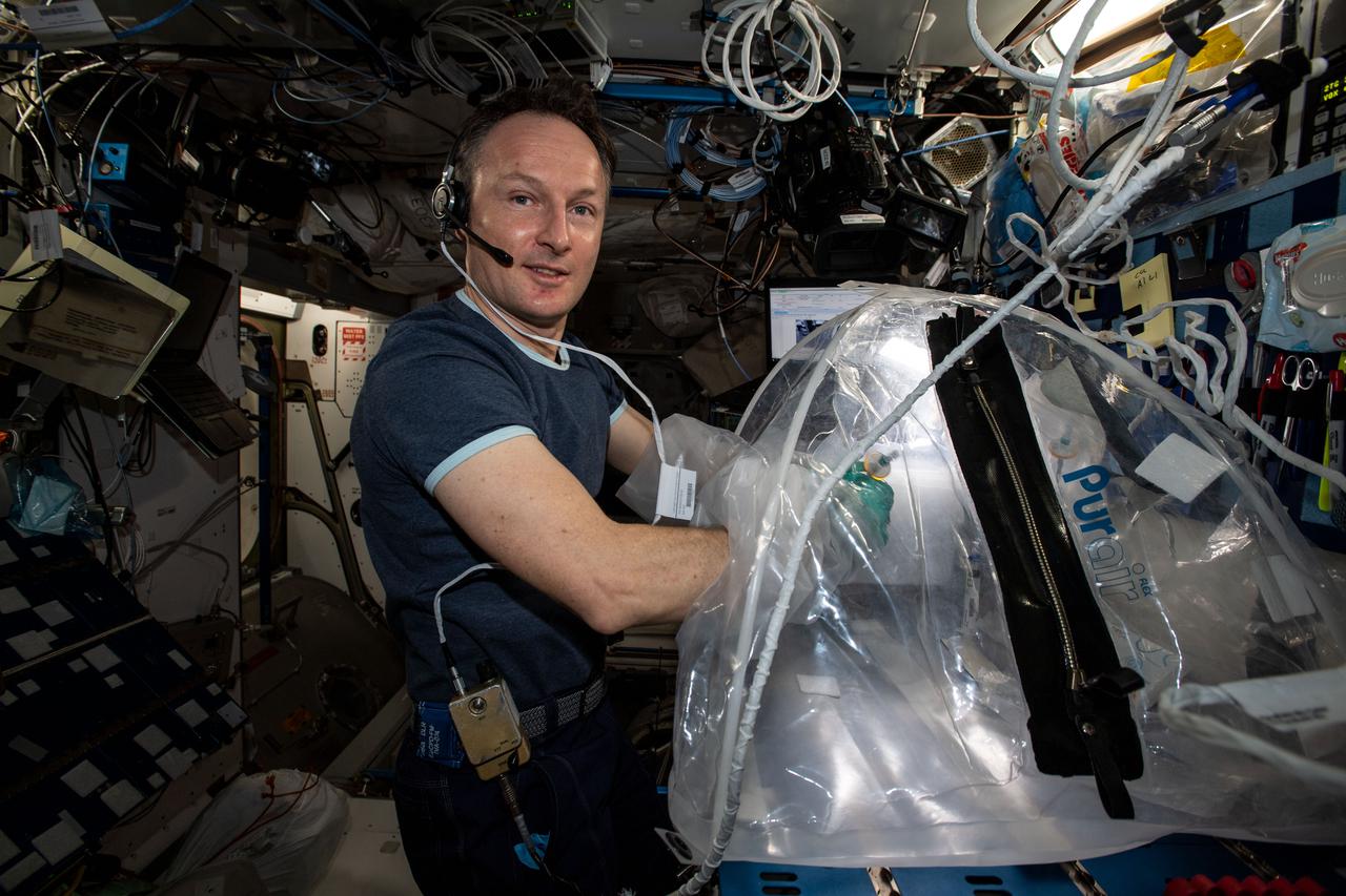 iss066e137033 (Feb. 1, 2022) --- ESA (European Space Agency) astronaut and Expedition 66 Flight Engineer Matthias Maurer explores how concrete hardens with the lack of gravity to inform future space construction techniques on lunar and planetary surfaces. Maurer conducts research operations in the portable glovebag with a variety of cement mixtures observing how pores, bubbles and crystals develop as the samples harden.