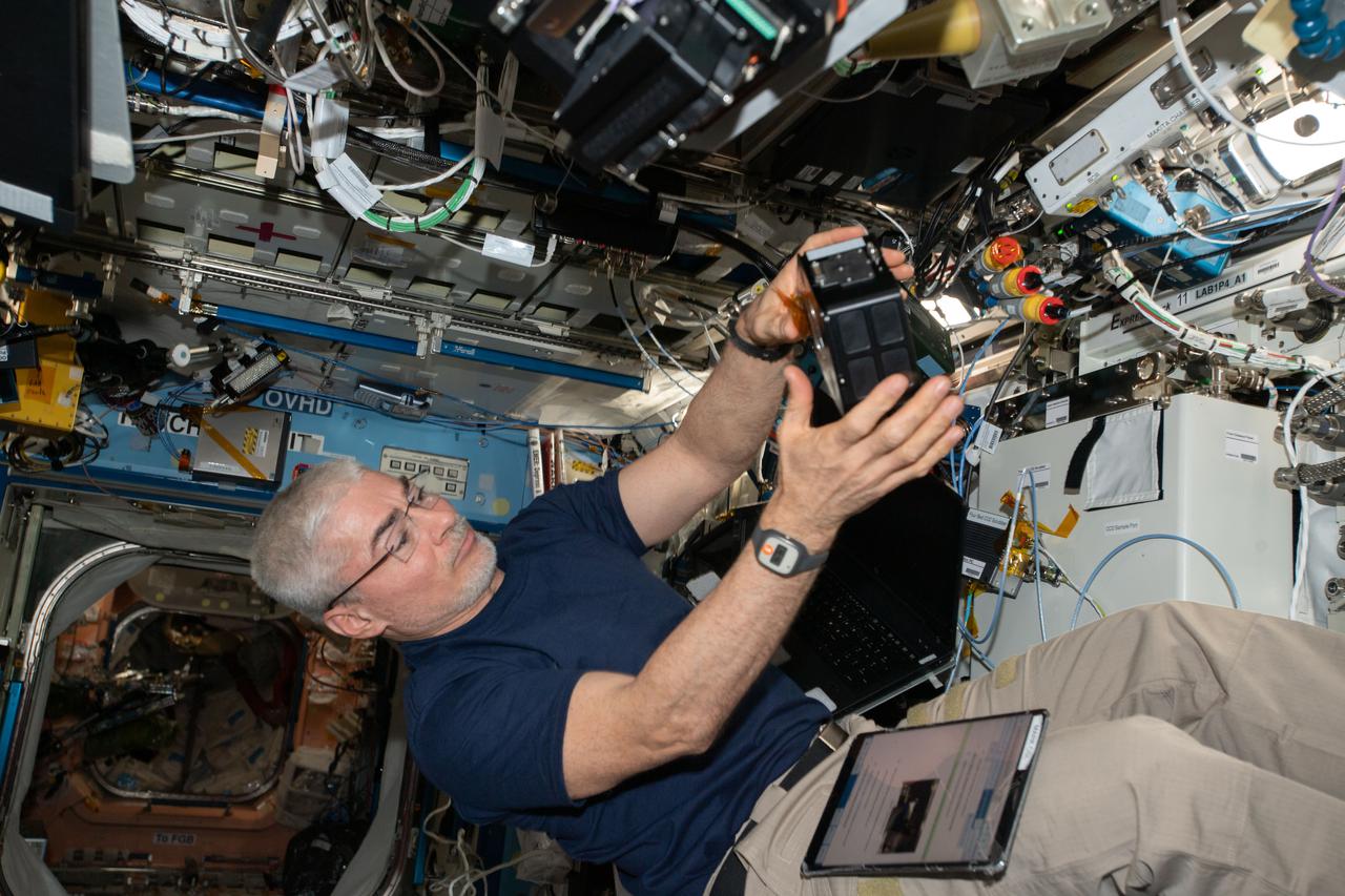 iss066e137913 (Feb. 9, 2022) --- NASA astronaut and Expedition 66 Flight Engineer Mark Vande Hei services components inside the Multi-use Variable-G Platform, a biology research device that can generate up to 2G of artfifical gravity.