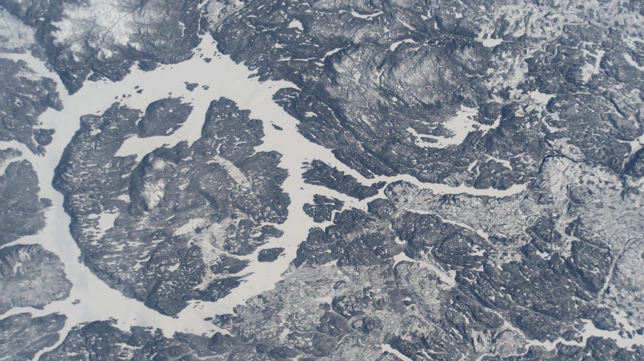 iss066e141220 (Feb. 13, 2022) --- The icy terrain surrounding the Manicouagan Reservoir, a lake formed by a prehistoric meteorite impact, is pictured from the International Space Station as it orbited 261 miles above far eastern Canada.