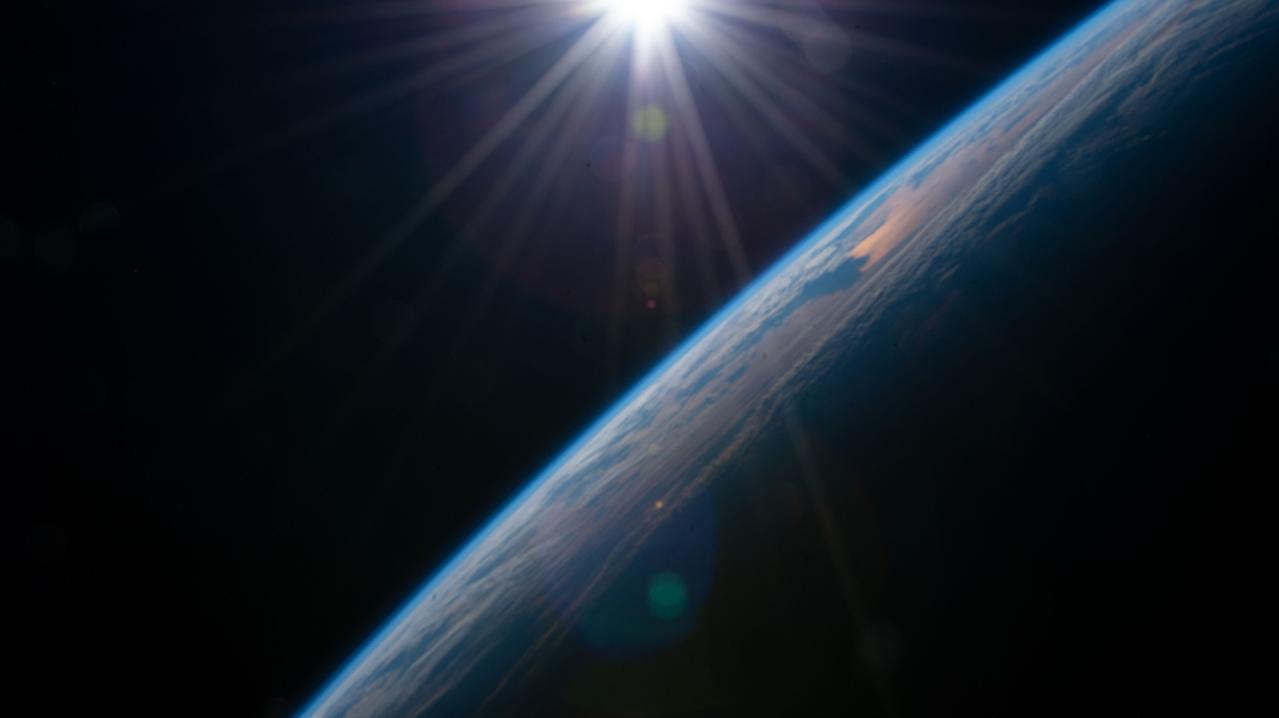 iss066e152100 (Feb. 22, 2022) --- The sun rises above the horizon illuminating the Earth in this photograph from the International Space Station as it orbited 262 above the Pacific Ocean south of Alaska's Aleutian Islands.