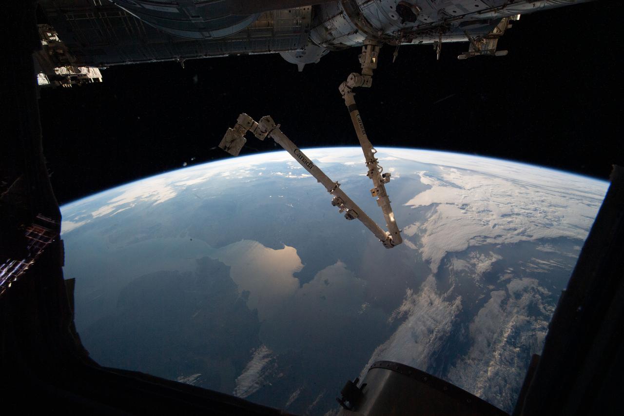 iss066e153504 (Feb. 27, 2022) --- The 57.7-foot-long Canadarm2 robotic arm is pictured extending from the Harmony module as the International Space Station orbited 264 miles above the Atlantic Ocean off the coast of Ireland and the United Kingdom.