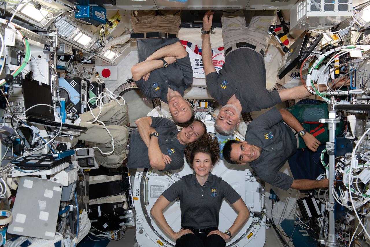 iss066e161539 (March 13, 2022) --- Members of the Expedition 66 crew pose for a group picture in the Japanese Experiment Module (JEM) aboard the International Space Station. Clockwise from bottom center are Expedition 66 Flight Engineers NASA astronaut Kayla Barron, NASA astronaut Tom Marshburn, European Space Agency (ESA) astronaut Matthias Maurer, NASA astronaut Mark Vande Hei, and NASA astronaut Raja Chari.