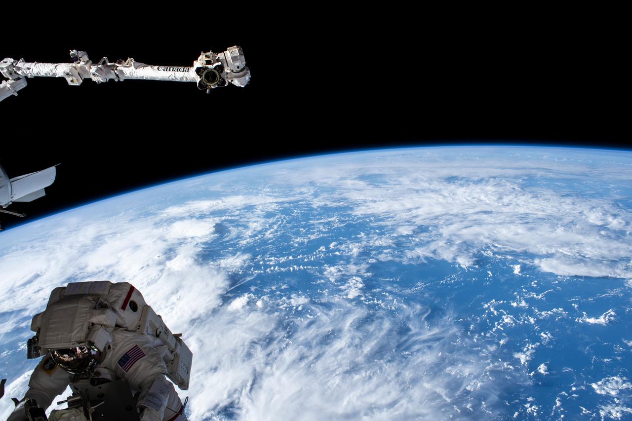 iss066e166153 (March 15, 2022) --- NASA astronaut Kayla Barron is pictured tethered to the International Space Station during a six-hour and 54-minute spacewalk to set up the orbital lab for its next roll-out solar array. Behind her is the Canadarm2 robotic arm with the Indian Ocean 263 miles below.