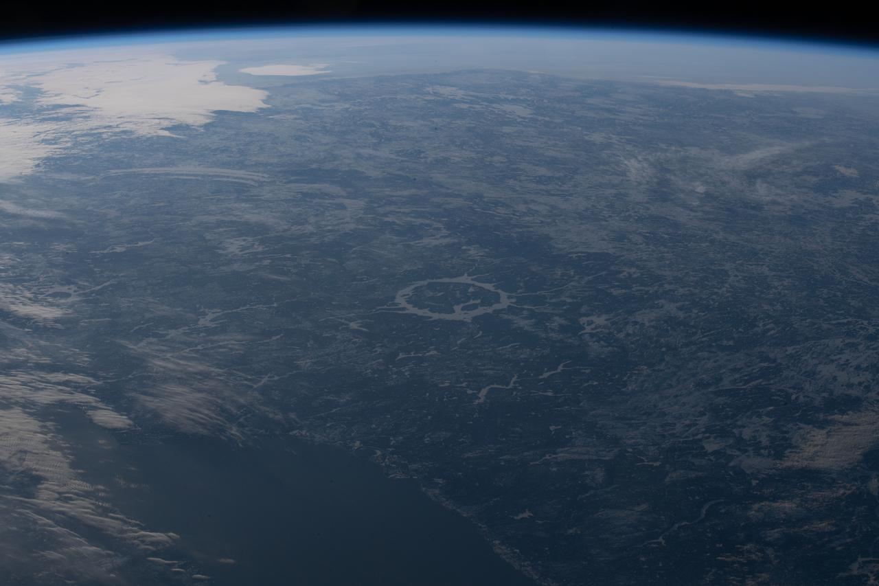 iss067e002988 (April 3, 2022) --- The Manicouagan Crater in Quebec, Canada, figures prominently in the center of this photograph from the International Space Station as it orbited 264 miles above the Atlantic Ocean off the coast of Newfoundland Island.