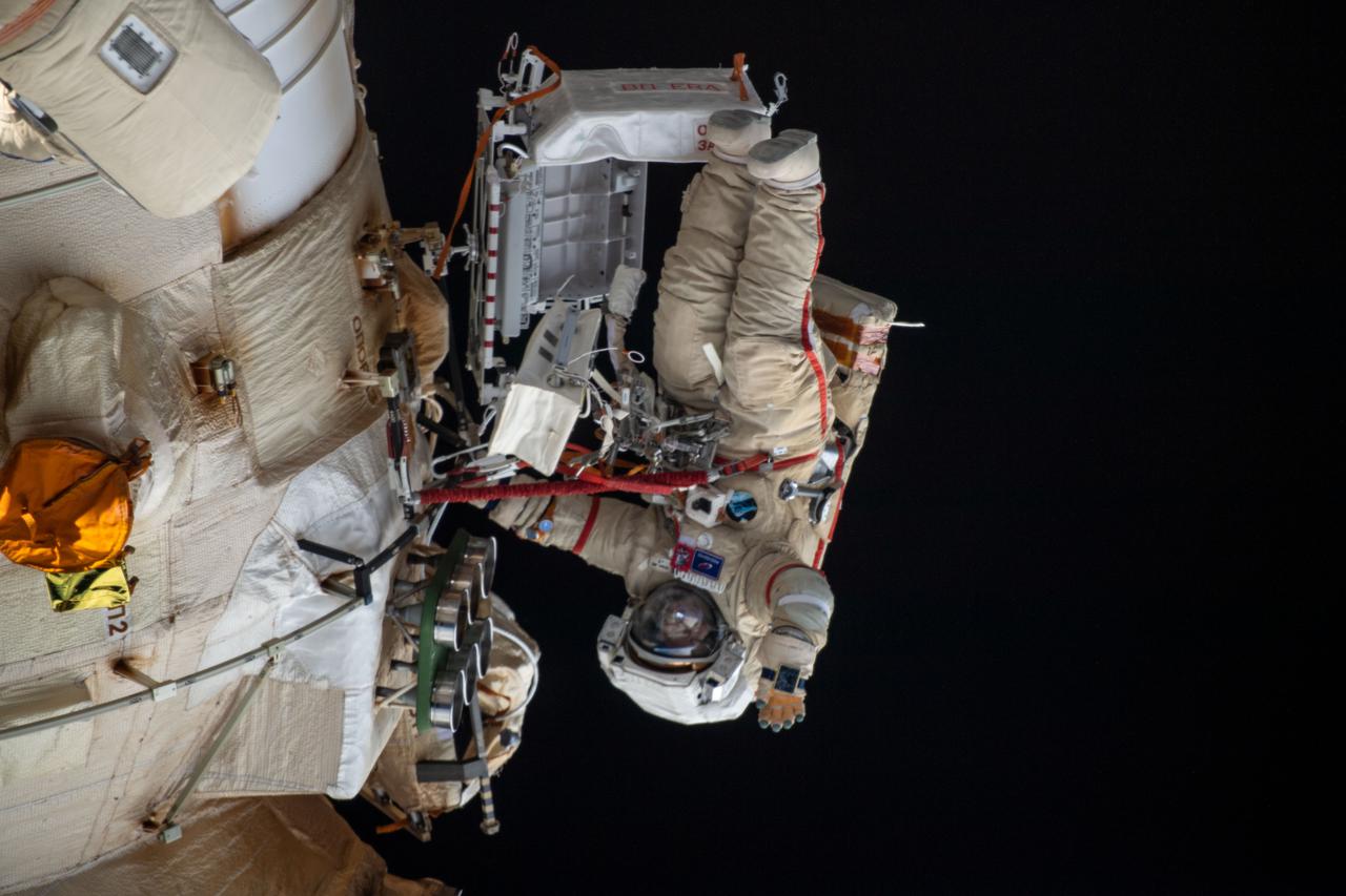 iss067e022050 (April 18, 2022) --- Cosmonaut Oleg Artemyev waves to the camera while working outside the Nauka multipurpose laboratory module during a spacewalk that lasted for six hours and 37 minutes to outfit Nauka and configure the European robotic arm on the International Space Station's Russian segment.