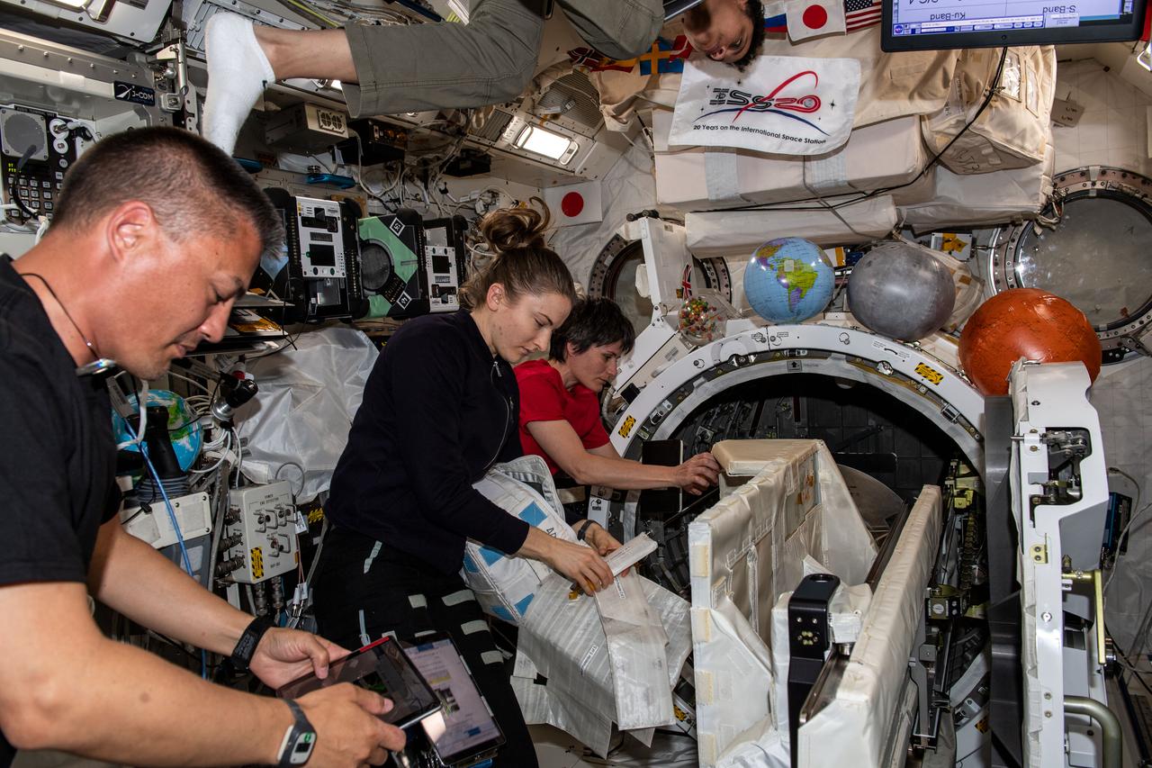 iss067e032346 (April 29, 2022) --- Expedition 67 Flight Engineers Kjell Lindgren and Kayla Barron, both from NASA, and Samantha Cristoforetti from ESA (European Space Agency) are pictured checking out systems inside the International Space Station's Kibo laboratory module. Partially visible at the top of this image, is NASA astronaut Jessica Watkins also participating in the station familiarization activities.