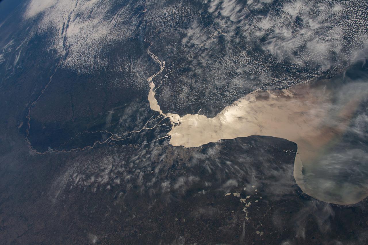 iss067e034832 (May 5, 2022) --- The Rio de la Plata separates the nations of Argentina (bottom) and Uruguay (top) in this photograph from the International Space Station as it orbited 270 miles above. Barely visible (at lower center), is the populous city of Buenos Aires, Argentina, at the mouth of the Paraná Delta which empties in to the Rio de la Plata.