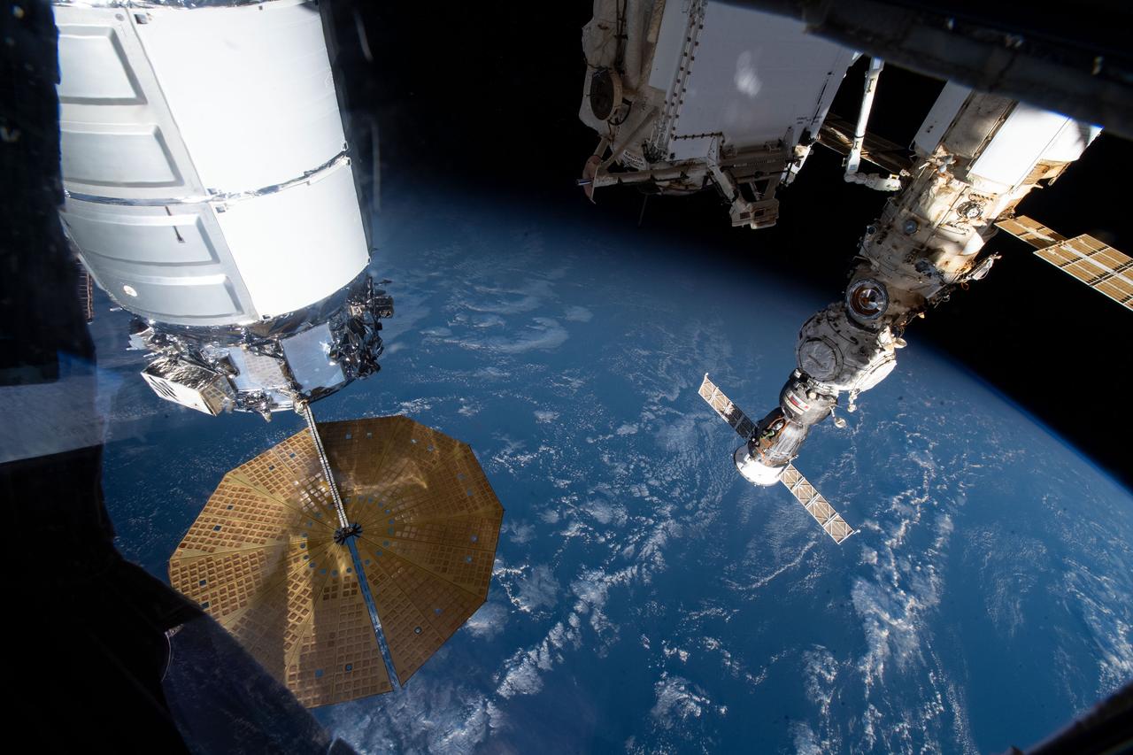 iss067e055885 (May 16, 2022) --- U.S. and Russian spaceships are pictured attached to the International Space Station as it orbited 267 miles above the Indian Ocean south of the island nation of Madagascar. At left, is the U.S. Northrop Grumman Cygnus resupply ship with its prominent cymbal-shaped UltraFlex solar arrays. At right, is the Soyuz MS-21 crew ship docked to the Prichal docking module, which is also attached to the Nauka multipurpose laboratory module. At top center, is the Rassvet module that also hosts Russian visiting vehicles.