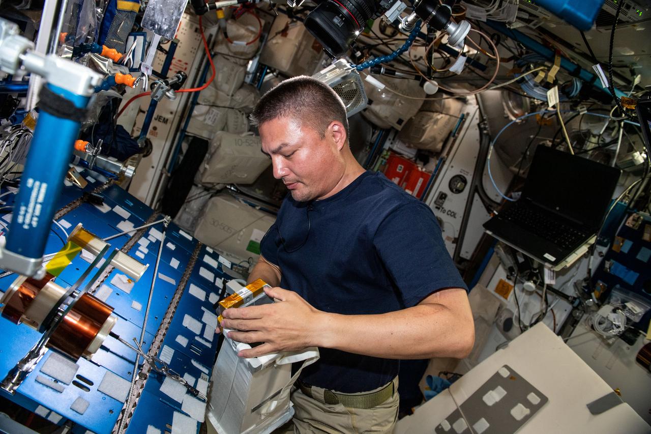 iss067e065353 (May 20, 2022) --- Expedition 67 Flight Engineer and NASA astronaut Kjell Lindgren checks airflow and water absorption capabilities on spacesuit components at the maintenance work area inside the International Space Station's Harmony module.