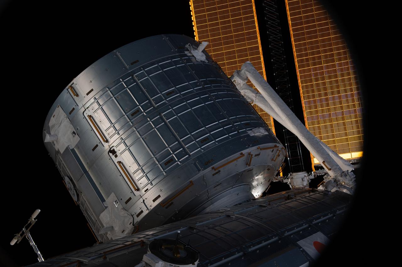 iss067e065625 (May 22, 2022) --- This view from a window on Boeing's CST-100 Starliner crew ship shows the Kibo laboratory module's logistics module from the Japan Aerospace Exploration Agency (JAXA) on the International Space Station. A portion of the Japanese robotic arm and the orbiting lab's main solar arrays are also visible.