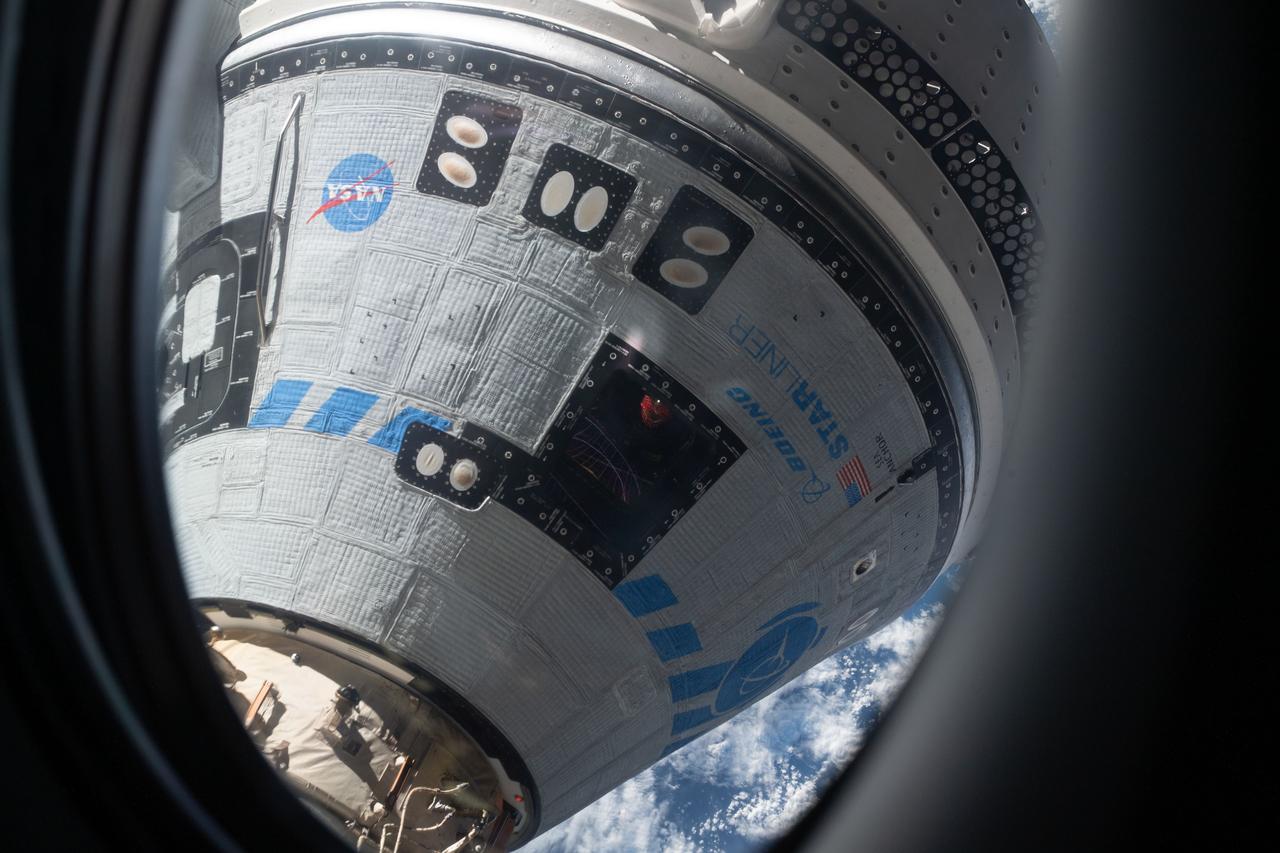 iss067e066295 (May 20, 2022) --- This view from a window on the SpaceX Crew Dragon Freedom crew ship shows Boeing's CST-100 Starliner crew ship after it had docked to the Harmony module's forward port on the International Space Station for the company's Orbital Flight Test-2 mission.