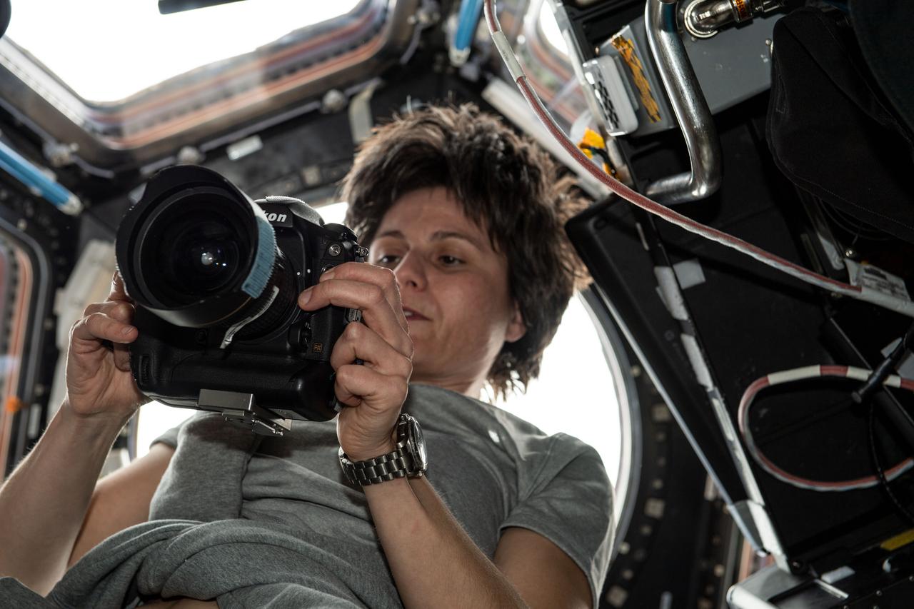 iss067e070688 (May 23, 2022) --- ESA (European Space Agency) astronaut and Expedition 67 Flight Engineer Samantha Cristoforetti checks out a camera inside the International Space Station's "window to the world," the seven-windowed cupola.