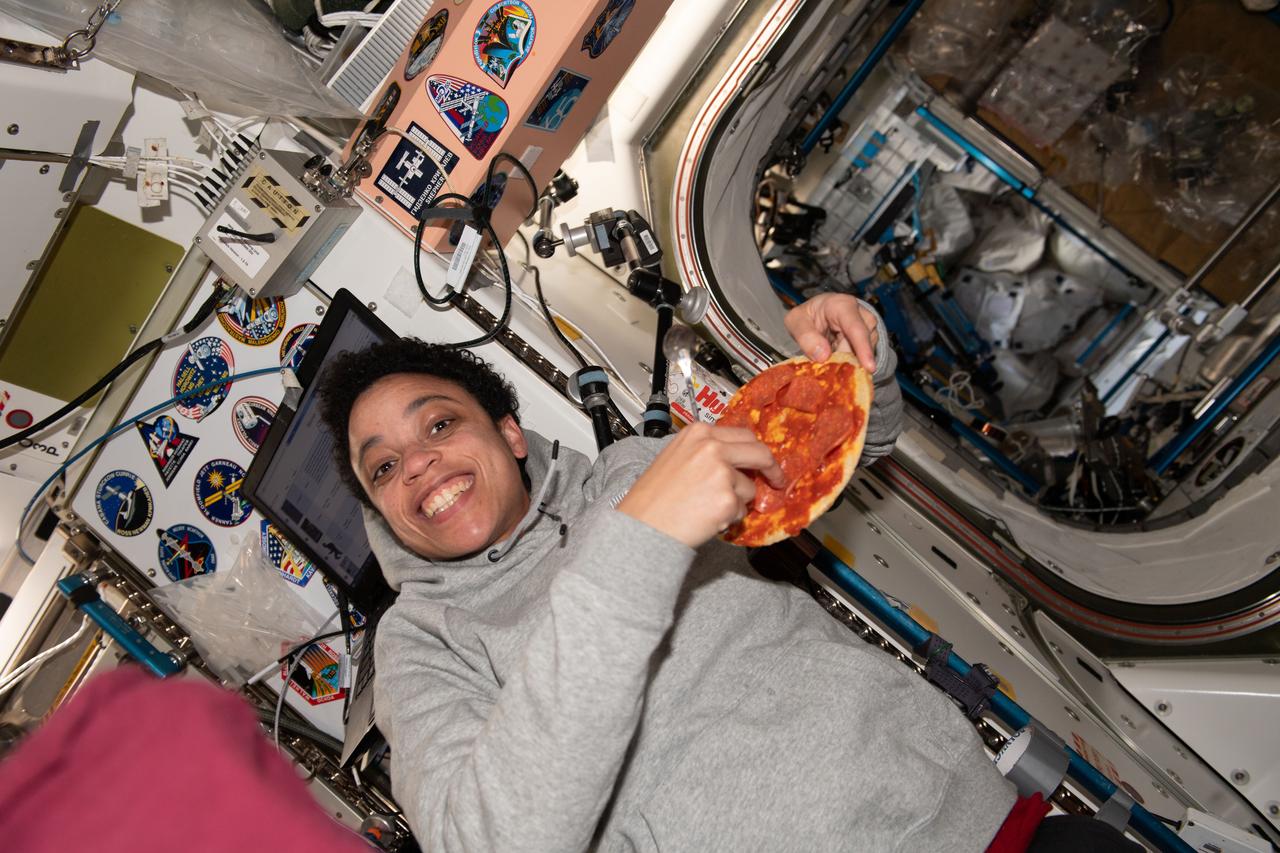 iss067e089040 (May 27, 2022) --- NASA astronaut and Expedition 67 Flight Engineer Jessica Watkins enjoys a personal size pizza during dinner time aboard the International Space Station.