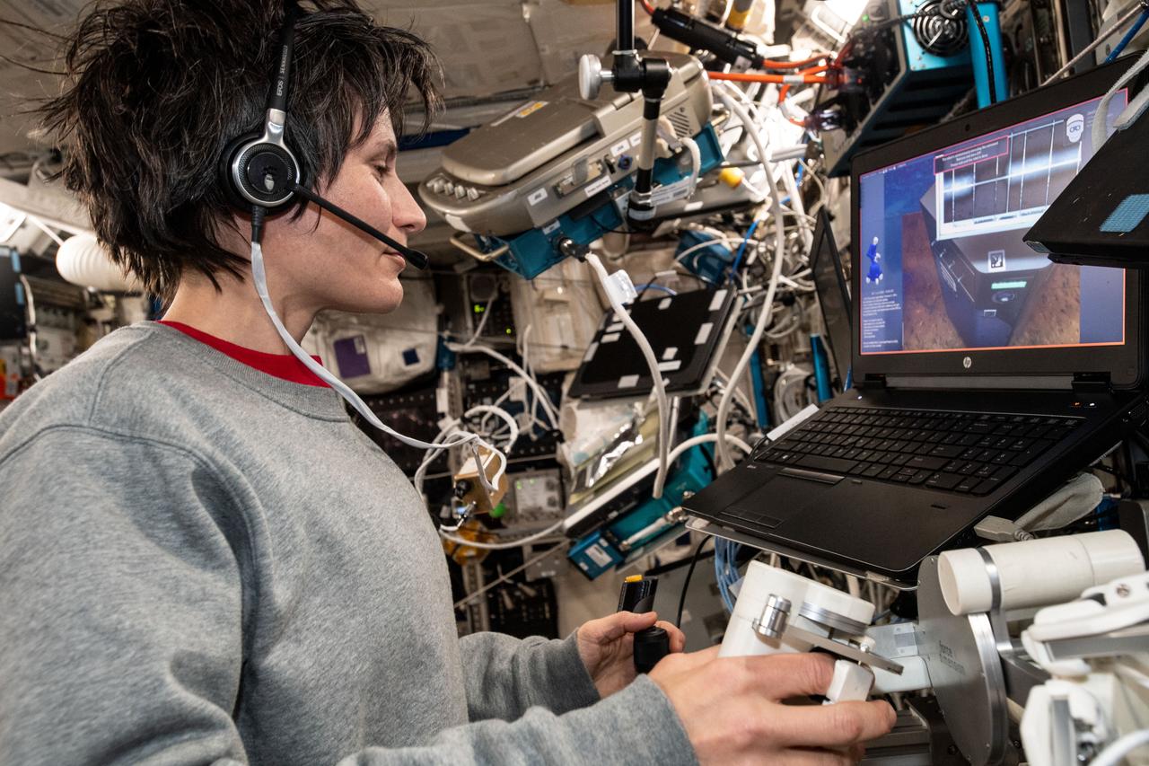 iss067e107123 (May 31, 2022) --- ESA (European Space Agency) astronaut and Expedition 67 Flight Engineer Samantha Cristoforetti practices robotics maneuvers on a laptop computer inside the International Space Station's Columbus laboratory module.