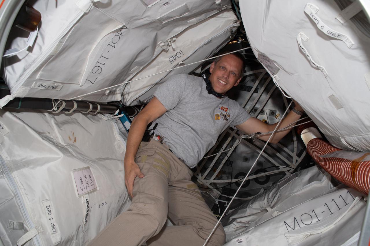 iss067e123265 (June 10, 2022) --- Expedition 67 Flight Engineer and NASA astronaut Bob Hines poses inside the Bigelow Expandable Activity Module (BEAM) packed with cargo and attached to the International Space Station's Tranquility module.