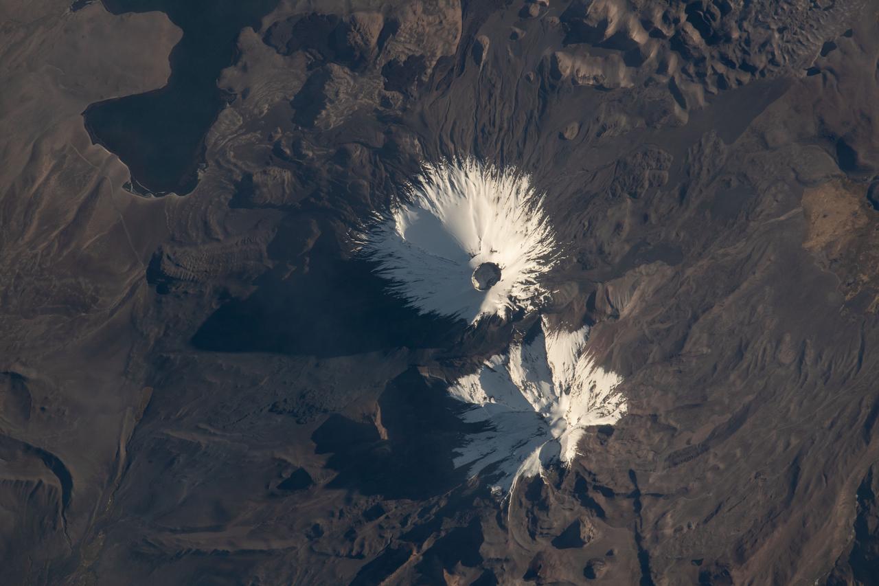 iss067e147189 (June 21, 2022) --- The Parinacota and Pomerape stratovolcanoes (top to bottom) are pictured from the International Space Station as it orbited 263 miles above the South American nation of Chile. Parinacota is a dormant volcano on the Chile-Bolivia border and its peak is about 20,800 feet. Pomerape, last active over 100,000 years ago, is also on the Chile- Bolivia border with an elevation of about 20,600 feet. At top left, is Chungará Lake in northern Chile which rests about 14,800 feet above sea level.