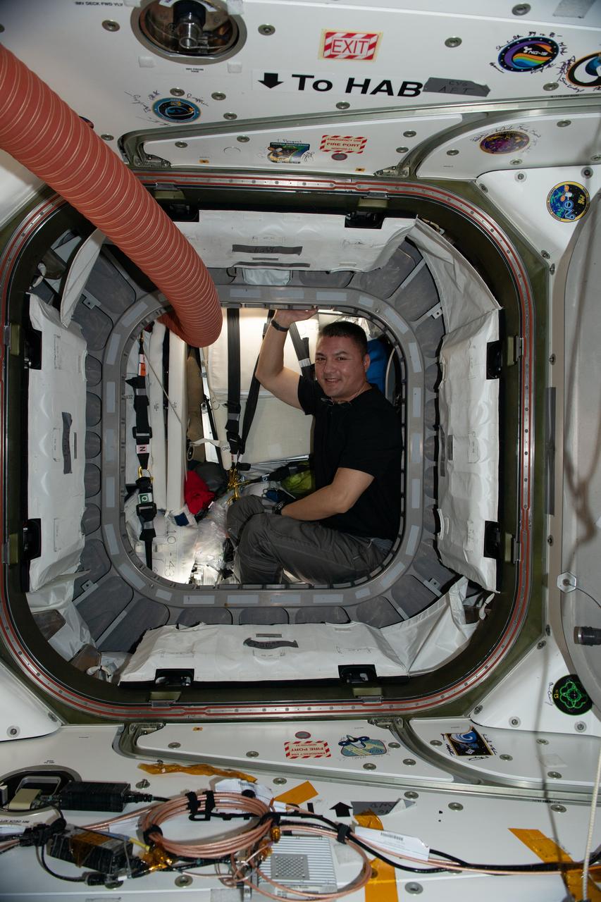 iss067e1549798 (June 27, 2022) --- NASA astronaut and Expedition 67 Flight Engineer Kjell Lindgren is pictured inside the vestibule between the Unity module and the Cygnus space freighter finalizing cargo operations the day before the vehicle's departure from the International Space Station.