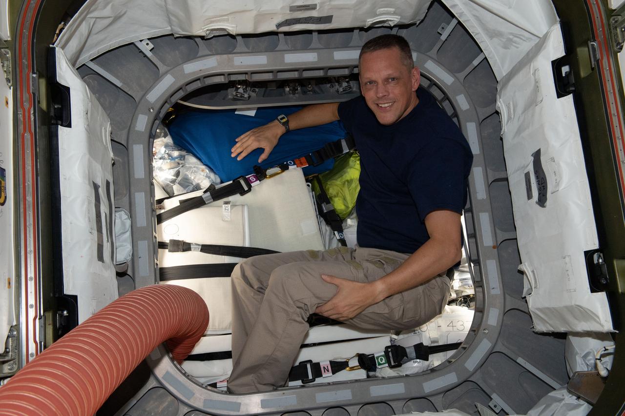 iss067e149814 (July 27, 2022) --- NASA astronaut and Expedition 67 Flight Engineer Bob Hines is pictured inside the vestibule between the Unity module and the Cygnus space freighter finalizing cargo operations the day before the vehicle's departure from the International Space Station.