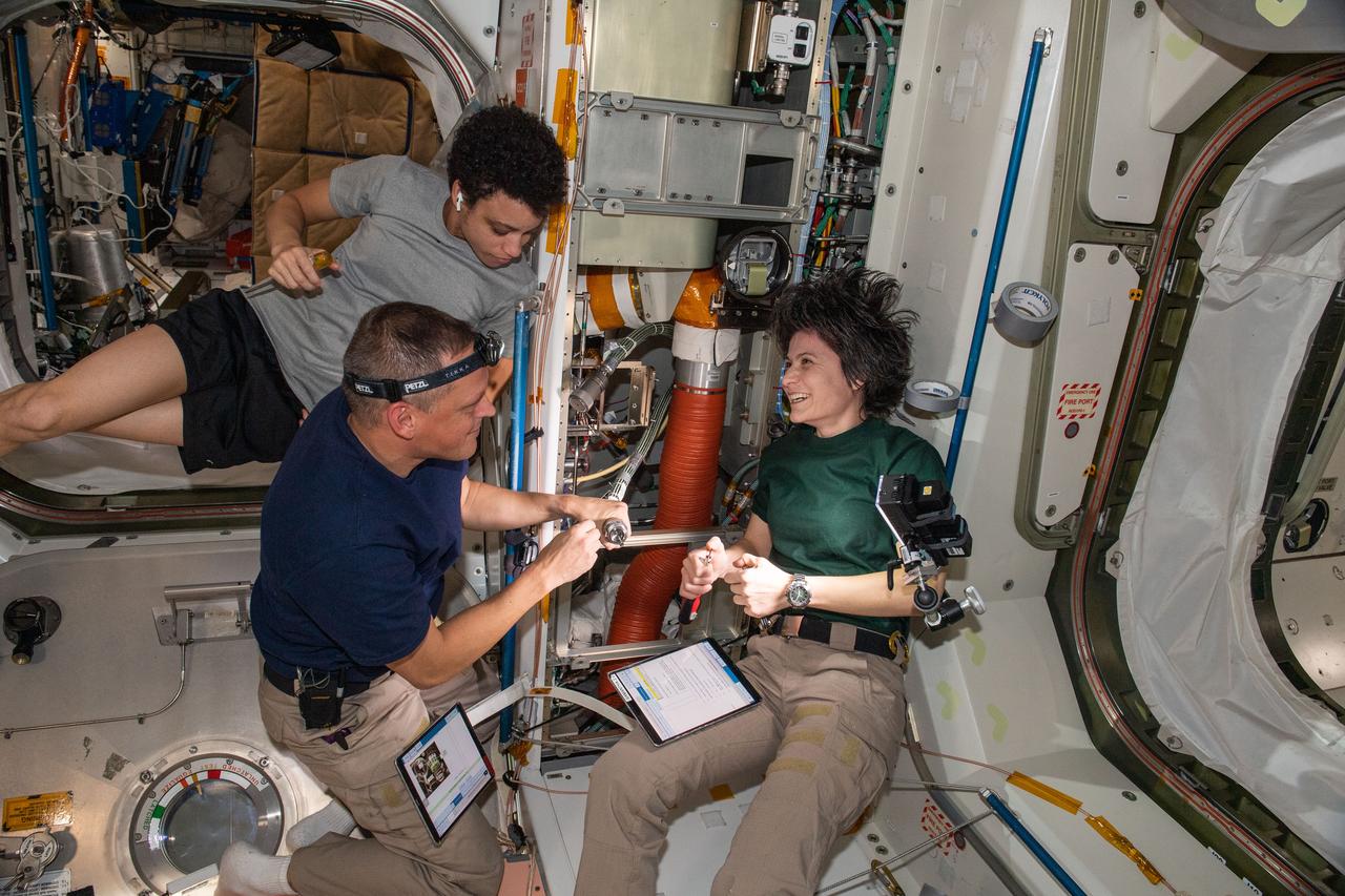 iss067e176560 (July 7, 2022) --- (Clockwise from right) Expedition 67 Flight Engineers Samantha Cristoforetti of ESA (European Space Agency), and Bob Hines and Jessica Watkins, both from NASA, check thermal system components inside the International Space Station's Unity module.