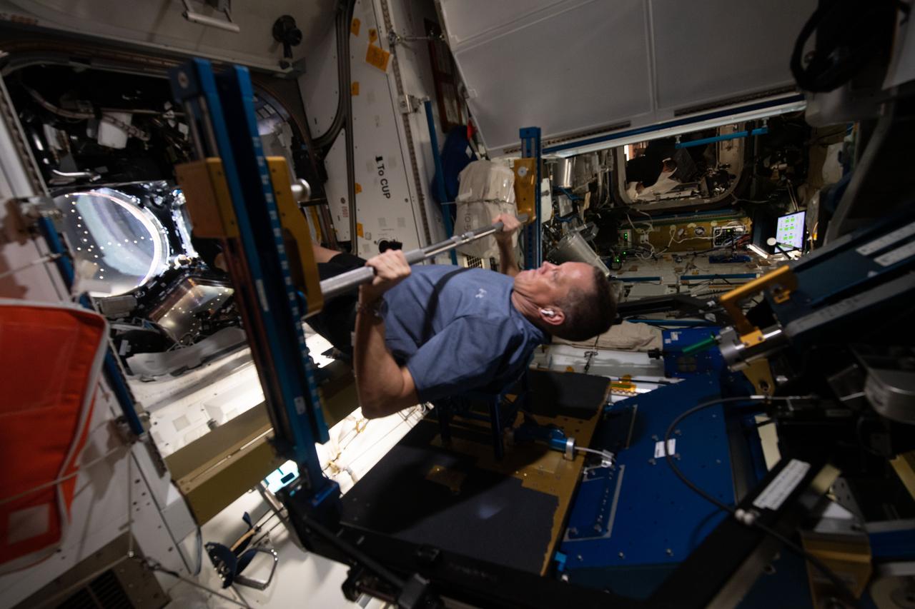 iss067e10951 (July 8, 2022) --- NASA astronaut and Expedition 67 Flight Engineer Bob Hines works out on the Advanced Resistive Exercise Device (ARED) inside the International Space Station's Tranquility module. The ARED mimics the inertial forces generated when lifting free weights on Earth enabling crew members to experience load and maintain muscle strength and mass during a long-term space mission.