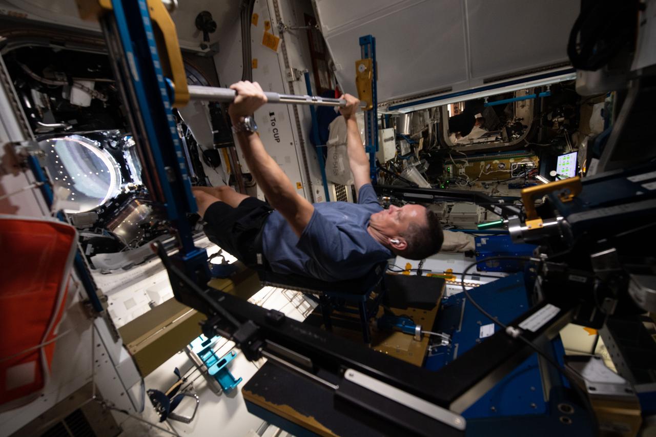 iss067e10952 (July 8, 2022) --- NASA astronaut and Expedition 67 Flight Engineer Bob Hines works out on the Advanced Resistive Exercise Device (ARED) inside the International Space Station's Tranquility module. The ARED mimics the inertial forces generated when lifting free weights on Earth enabling crew members to experience load and maintain muscle strength and mass during a long-term space mission.