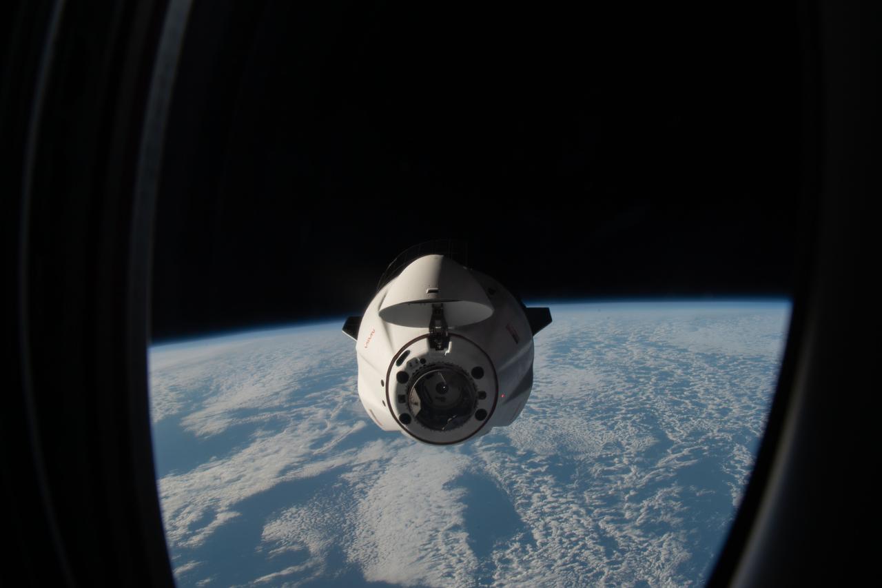 iss067e188909 (July 16, 2022) --- The SpaceX Dragon resupply ship carrying over 5,800 pounds of new science experiments and crew supplies, pictured from a window on the SpaceX Dragon Freedom crew ship, approaches the International Space Station above the south Atlantic Ocean.