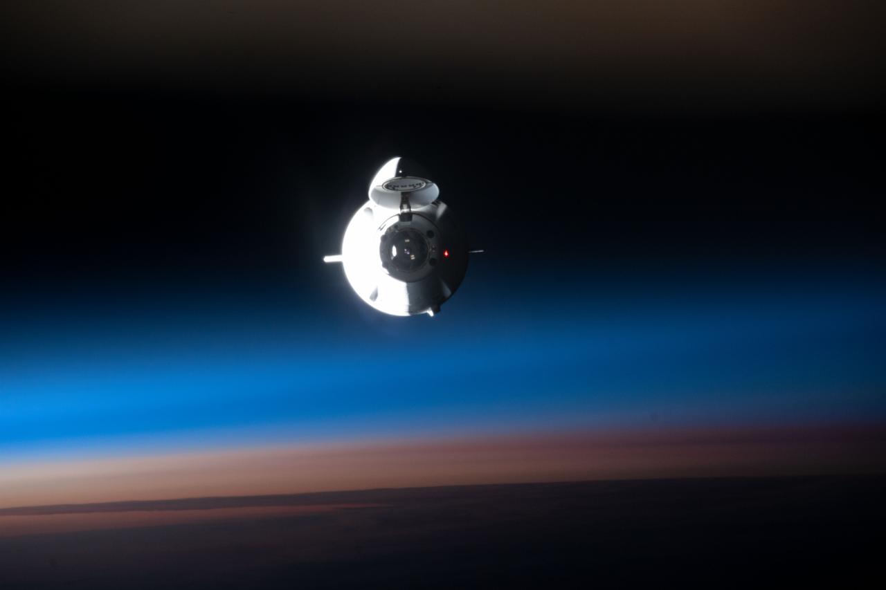 iss067e189232 (July 16, 2022) --- The SpaceX Dragon space freighter, on its 25th Commercial Resupply Services mission, approaches the International Space Station during an orbital sunrise 263 miles above the Pacific Ocean.