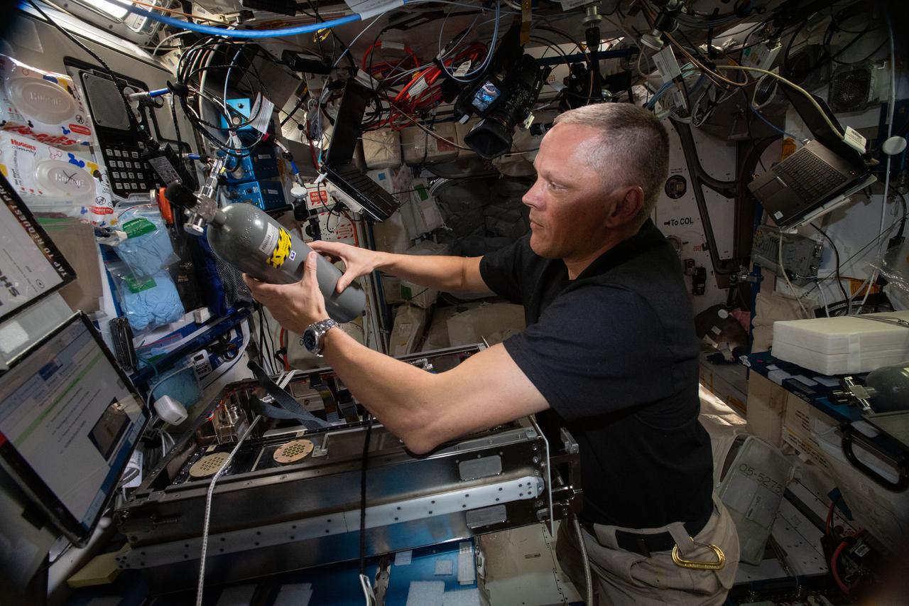 iss067e249841 (Aug. 9, 2022) --- NASA astronaut and Expedition 67 Flight Engineer Bob Hines works inside the International Space Station's Harmony module and replaces a carbon dioxide bottle inside the Plant Habitat Facility that supports space agricultural research.