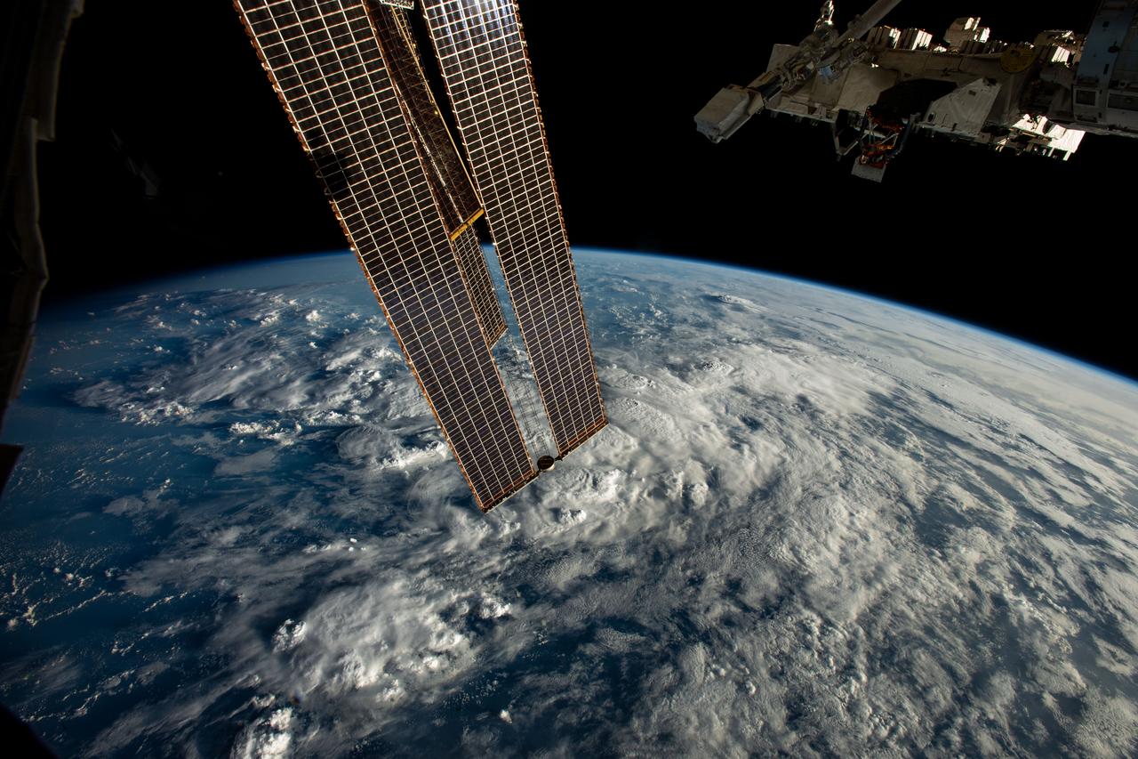 iss067e253816 (Aug. 12, 2022) --- A set of the International Space Station's main solar arrays and the Kibo laboratory module's external pallet (top right) are pictured as the orbiting lab soared 260 miles above a cloudy Atlantic Ocean off the coast of northern Brazil.