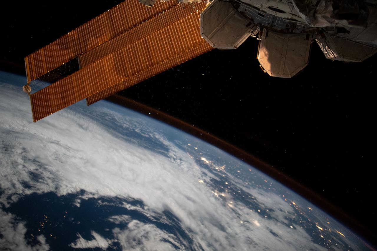iss067e255755 (Aug. 10, 2022) --- The city lights of Brazil sparkle underneath cloudy skies and a dim atmospheric glow as the International Space Station orbited 263 miles above the Atlantic Ocean off the coast of the South American nation.