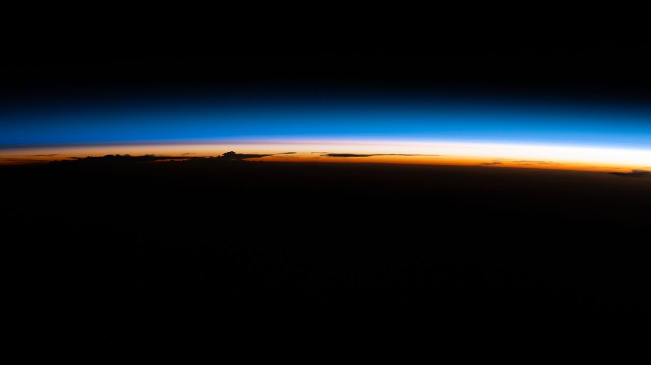 iss067e265876 (Aug. 13, 2022) --- An orbital sunrise illuminate's Earth's atmosphere silhouetting clouds as the International Space Station soared 264 miles above the Paraguay-Brazil border in South America.