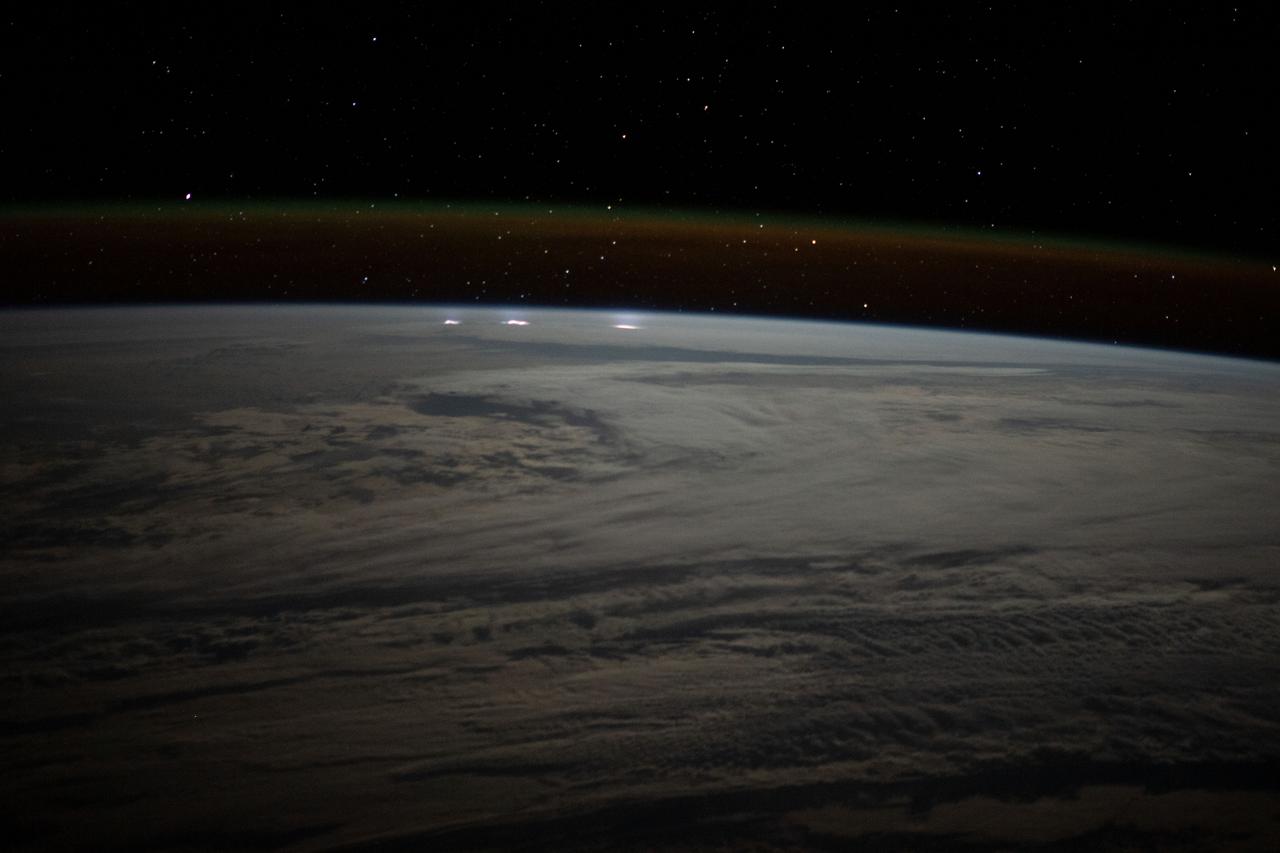 iss067e270871 (Aug. 17, 2022) --- A cloudy, south Indian Ocean between Africa and Antarctica, with lightning storms near the horizon beneath the atmospheric glow, is pictured from the International Space Station as it orbited 271 miles above