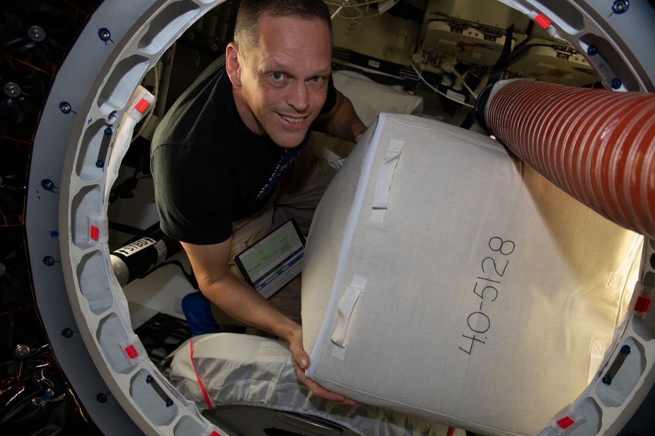 iss067e273982 (Aug. 14, 2022) --- NASA astronaut and Expedition 67 Flight Engineer Bob Hines is pictured packing cargo inside the SpaceX Dragon resupply ship before it undocked from the International Space Station on Aug. 19, 2022.