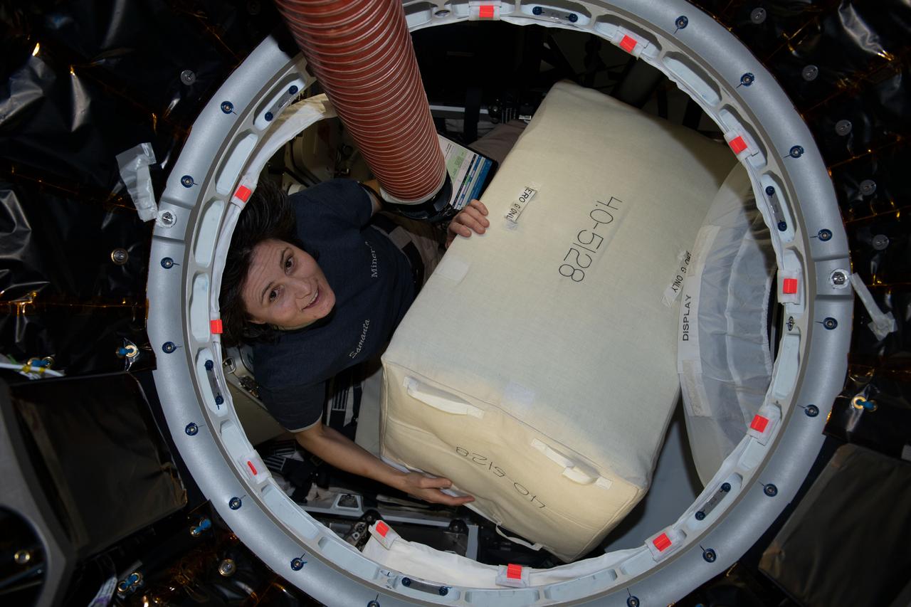 iss067e273989 (Aug. 14, 2022) --- ESA (European Space Agency) astronaut and Expedition 67 Flight Engineer Samantha Cristoforetti is pictured packing cargo inside the SpaceX Dragon resupply ship before it undocked from the International Space Station on Aug. 19, 2022.