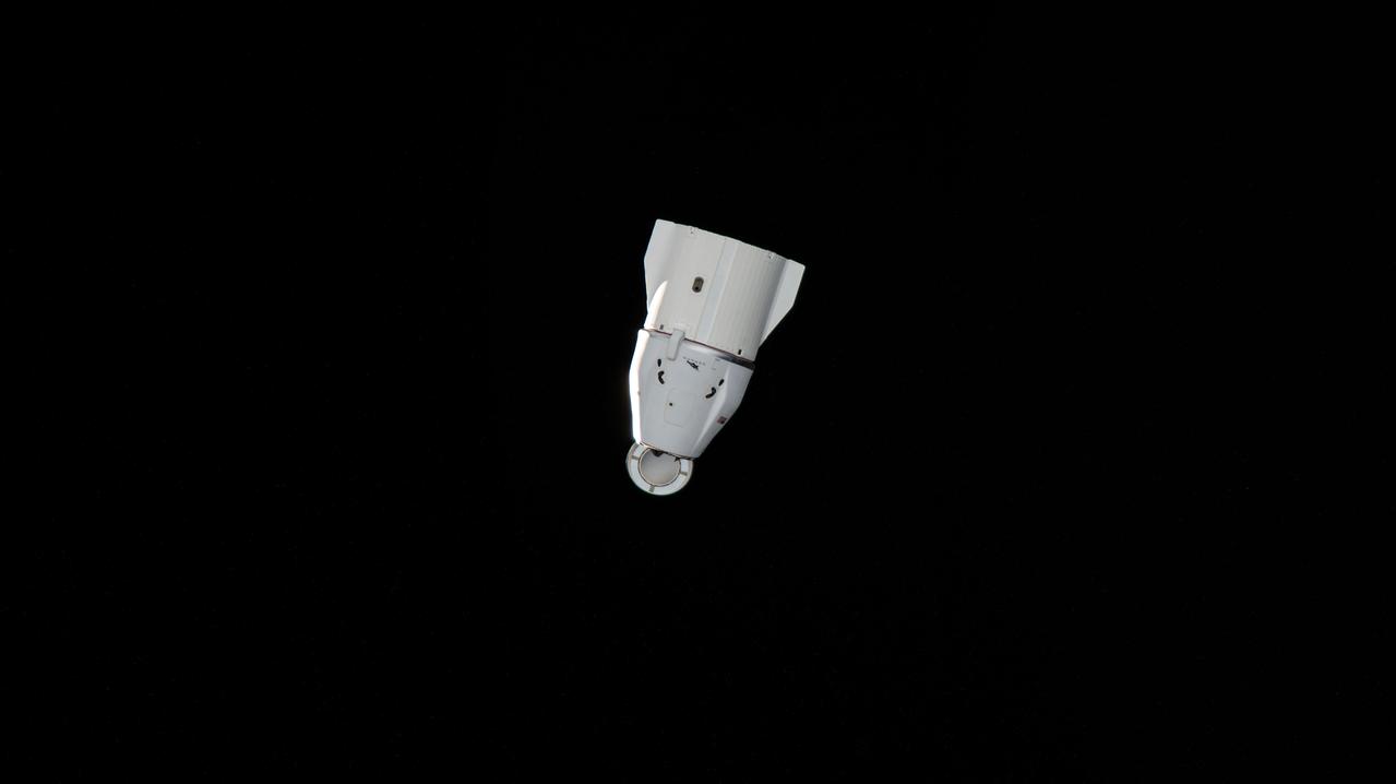 iss067e274277 (Aug. 19, 2022) --- The SpaceX Dragon resupply ship, packed with over 4,000 pounds of return cargo and science experiments for analysis, is pictured departing the vicinity of the International Space Station several minutes after undocking from the Harmony module's forward port.
