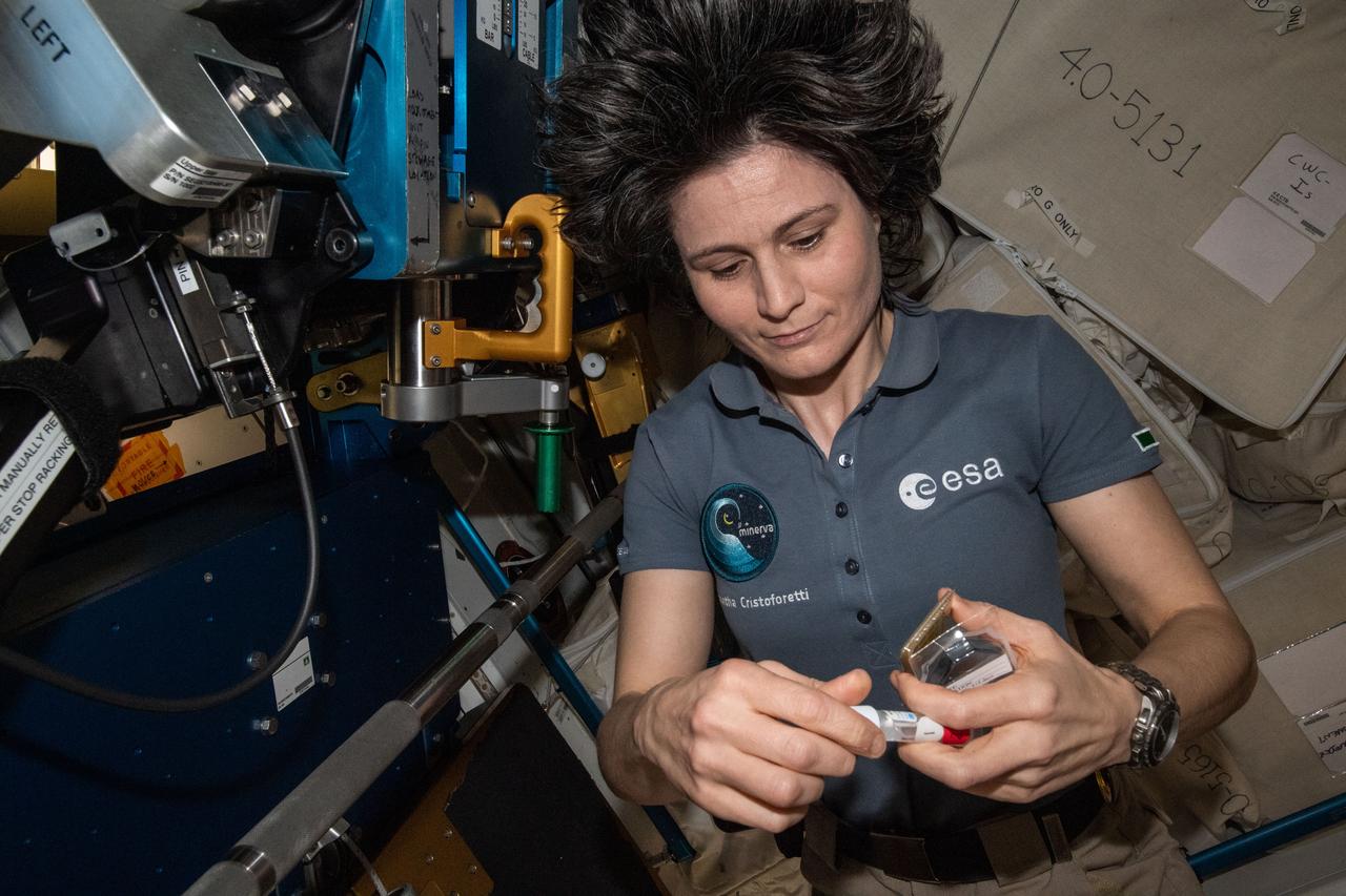 iss067e344865 (Sept. 8, 2022) --- Expedition 67 Flight Engineer Samantha Cristoforetti of ESA (European Space Agency) services microbe samples collected for analysis from areas around the Columbus laboratory module's Veggie space botany facility.