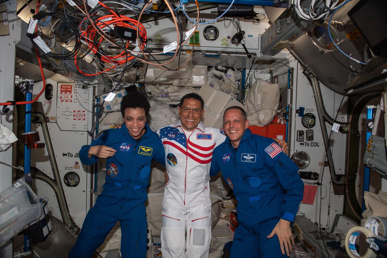 iss067e376730 (Sept. 21, 2022) --- NASA astronaut Frank Rubio (center) is greeted by fellow NASA astronauts Jessica Watkins and Bob Hines shortly after he arrived at the International Space Station. Rubio docked to the orbiting lab's Rassvet module earlier with Roscosmos cosmonauts (out of frame) Sergey Prokopyev and Dmitri Petelin aboard the Soyuz MS-22 crew ship beginning a six-month space research mission.