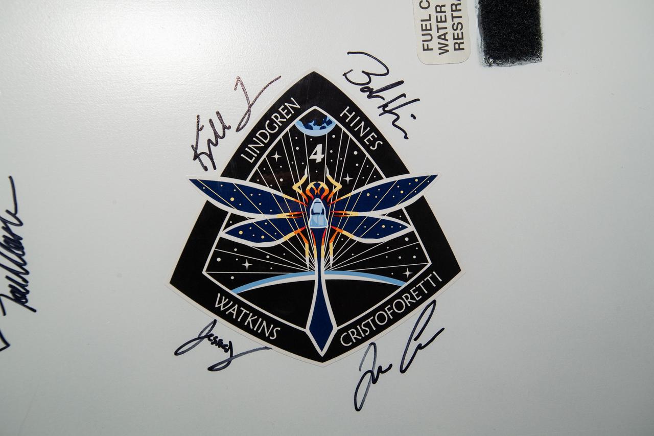 iss068e016463 (Oct. 12, 2022) --- The SpaceX Crew-4 mission insignia, affixed to the vestibule between the Harmony module's space-facing port and the Dragon Freedom crew ship, is surrounded by the signatures of Crew-4 members Kjell Lindgren, Bob Hines, Jessica Watkins, and Samantha Cristoforetti. Credit: NASA/Kjell Lindgren