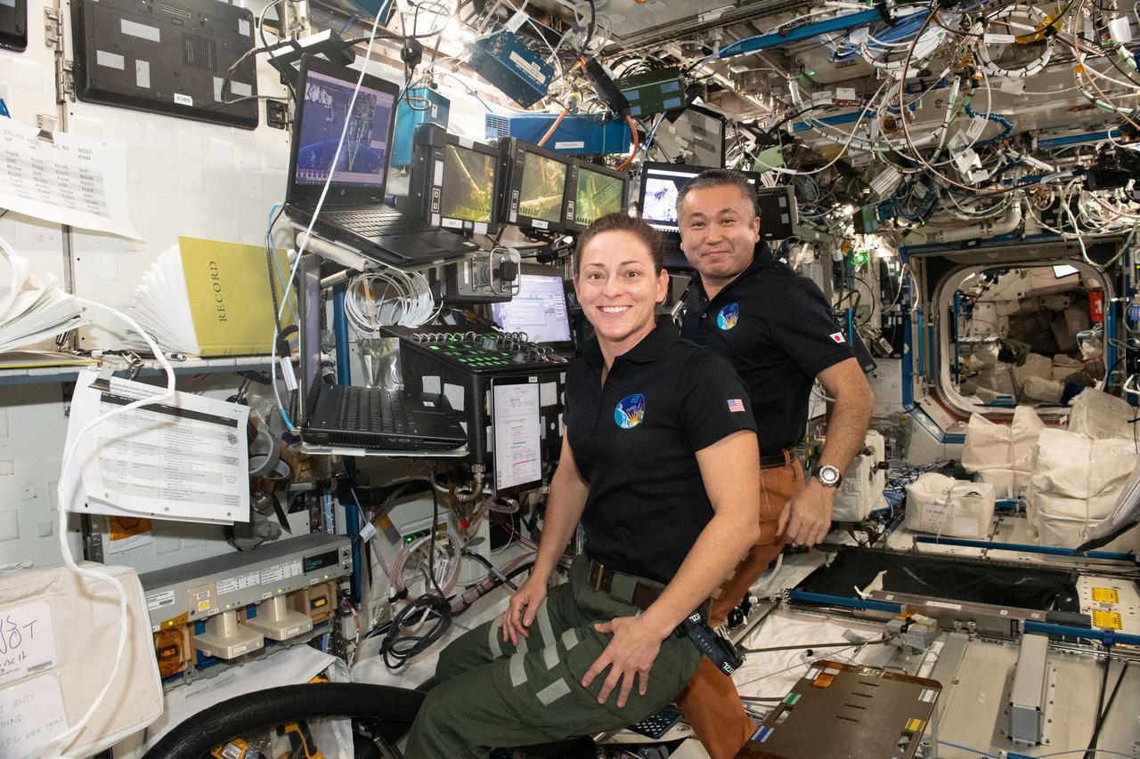iss068e026335 (Dec. 3, 2022) --- Flight Engineers Nicole Mann of NASA and Koichi Wakata of the Japan Aerospace Exploration Agency (JAXA) are pictured at the robotics workstation that controls the Canadarm2 robotic arm from inside the International Space Station's Destiny laboratory module. The duo assisted NASA spacewalkers Josh Cassada and Frank Rubio (out of frame) who were on the outside of the orbiting lab installing a roll-out solar array on the Starboard-4 truss segment.