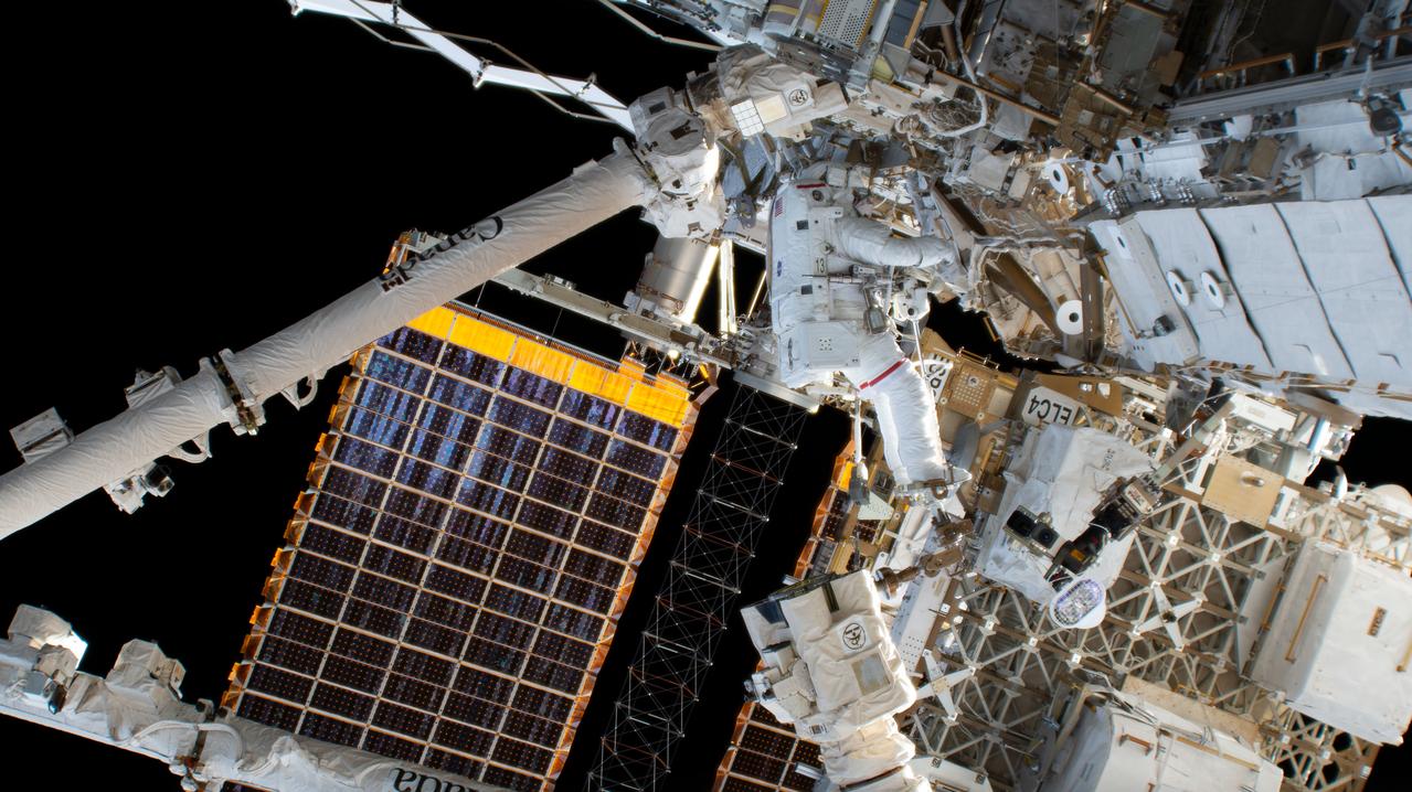 iss068e026399 (Dec. 3, 2022) --- NASA astronaut and Expedition 68 Flight Engineer Josh Cassada is attached to the Canadarm2 robotic arm during a spacewalk to install a roll-out solar array on the International Space Station's Starboard-4 truss segment.