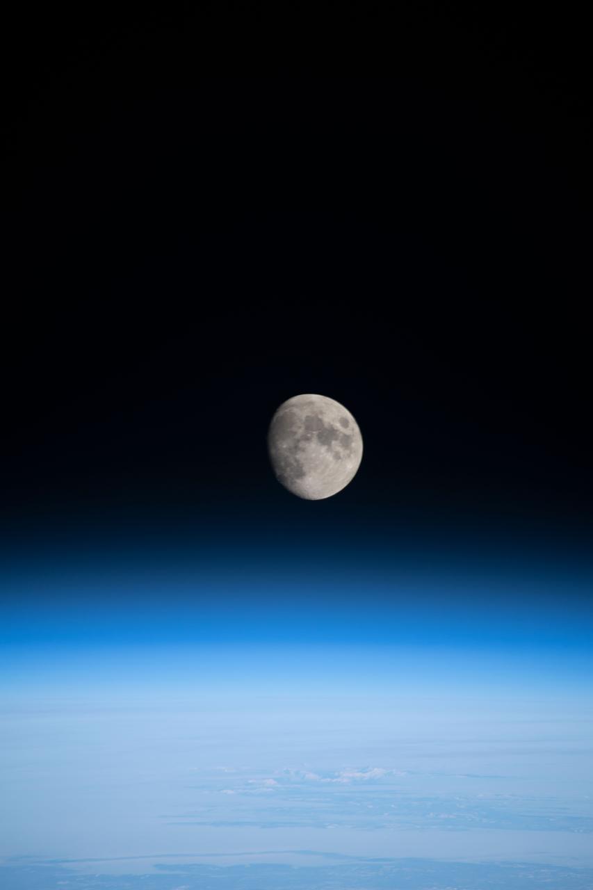 iss068e026678 (Dec. 4, 2022) --- The waxing gibbous Moon is pictured above Earth's horizon from the International Space Station as it orbited 261 miles over the northern Pacific Ocean. At the time of this photograph the Orion vehicle on the Artemis I mission was almost 24,000 miles away from the Moon and approximately 222,200 miles from Earth traveling at a speed of 3,076 miles per hour.
