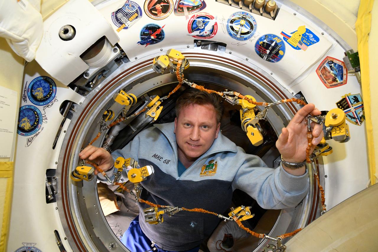 iss068e029376 (Dec. 12, 2022) --- Roscosmos cosmonaut and Expedition 68 Commander Sergey Prokopyev is pictured inside the vestibule between the ISS Progress 82 cargo craft and the Poisk module aboard the International Space Station.