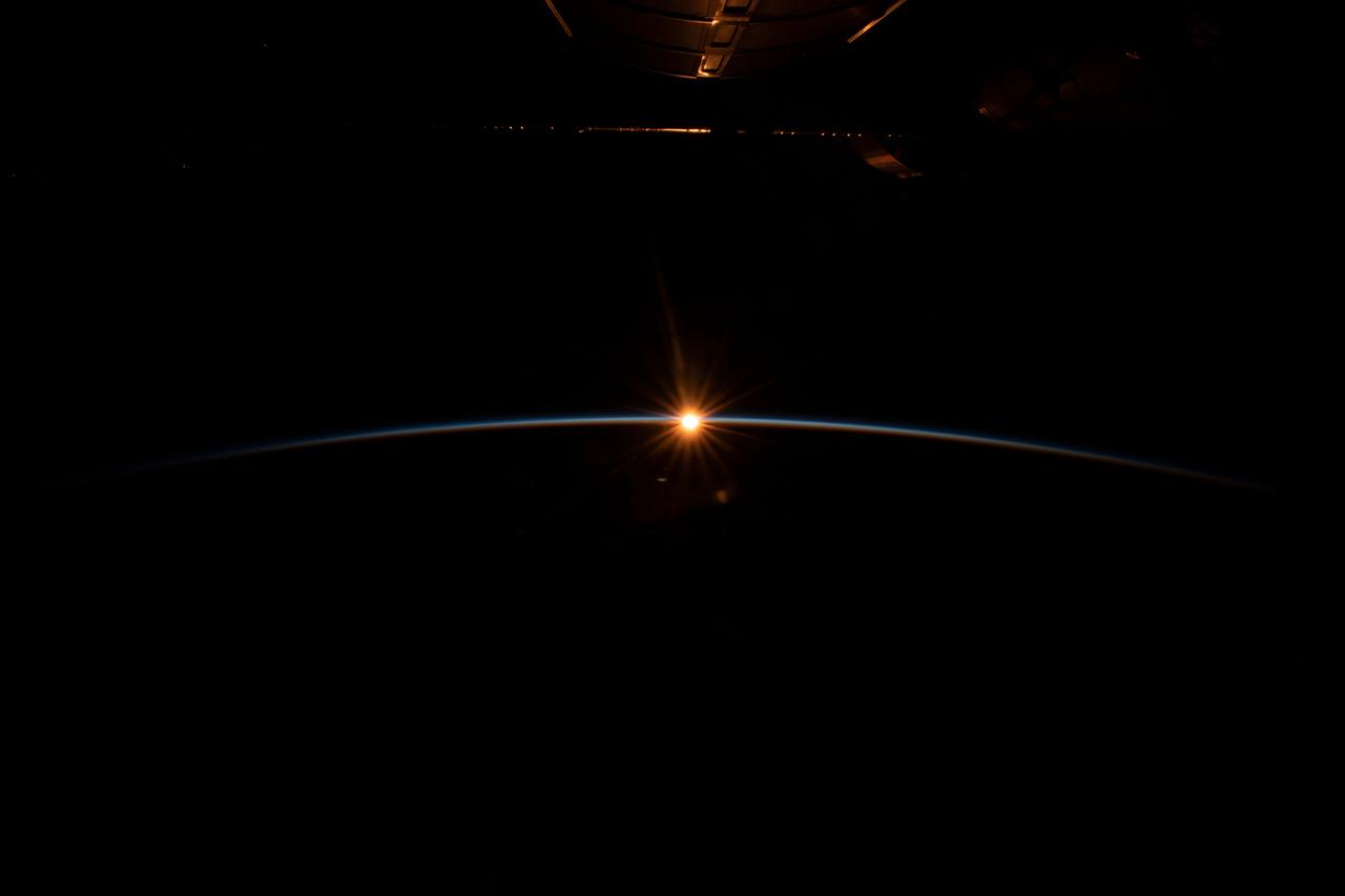 iss068e038496 (Dec. 31, 2022) --- The first rays of an orbital sunrise begin to illuminate the Earth's atmosphere and reflect off the Earth-facing portion of the International Space Station as it orbited 263 miles above the northern Pacific Ocean south of Alaska's Aleutian Island's.